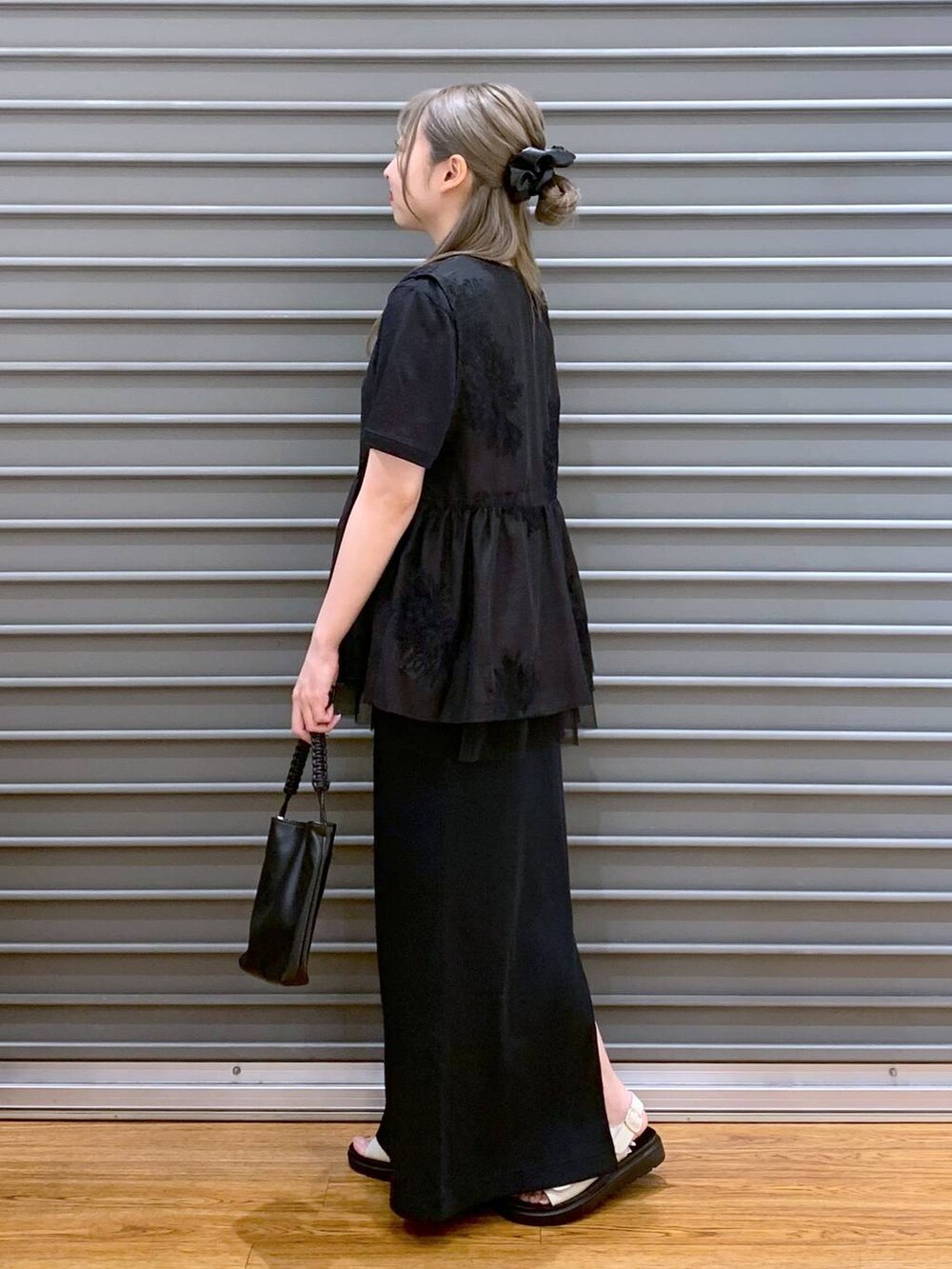 ホワイト系のサンダル、ブラック系のショルダーバッグ、ブラック系のシャツ/ブラウスを着用したレディースの夏コーディネートの3枚目の写真