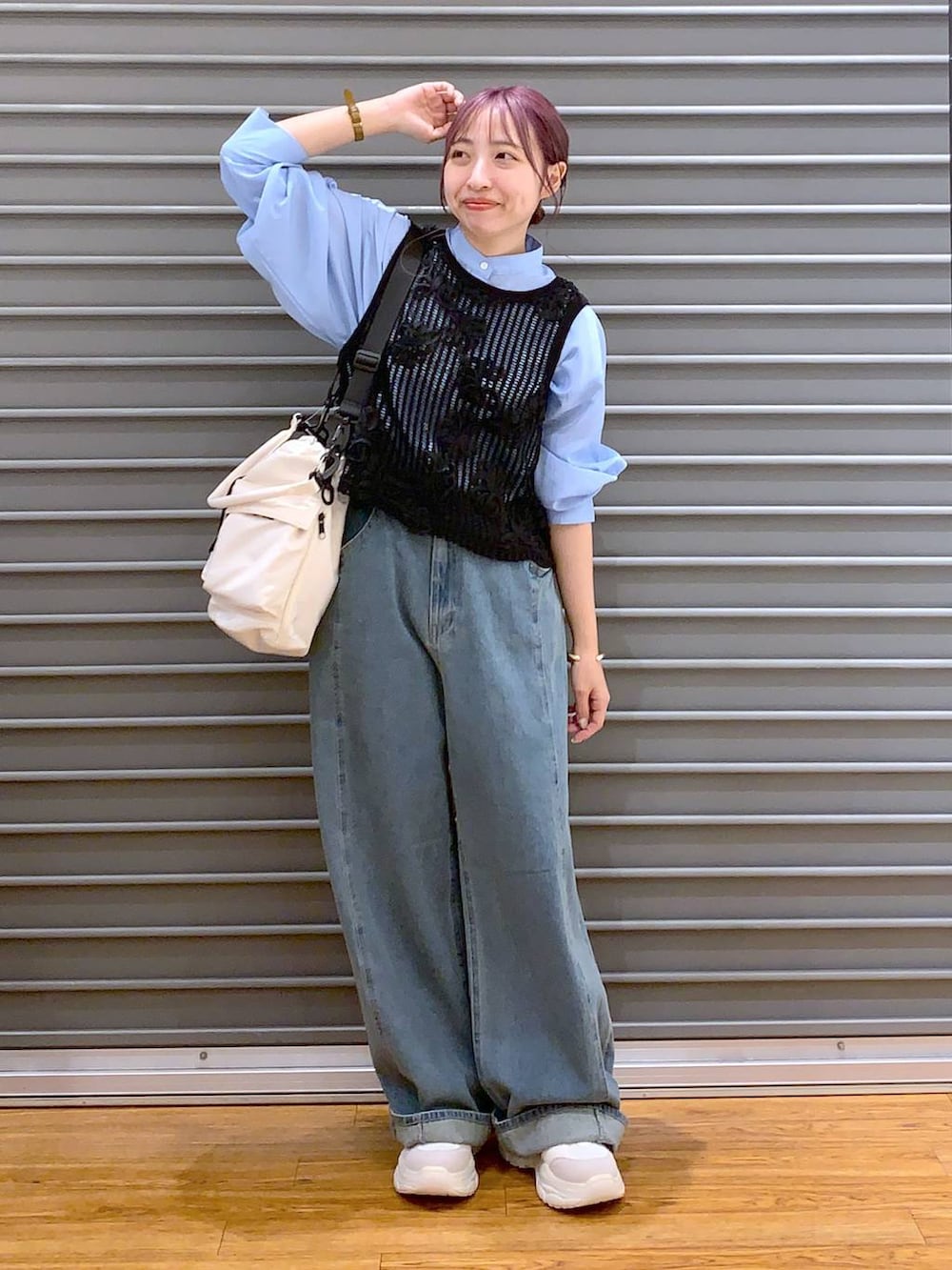 ホワイト系のショルダーバッグ、ブルー系のデニムパンツ、ホワイト系のスニーカーを着用したレディースの秋コーディネートの5枚目の写真