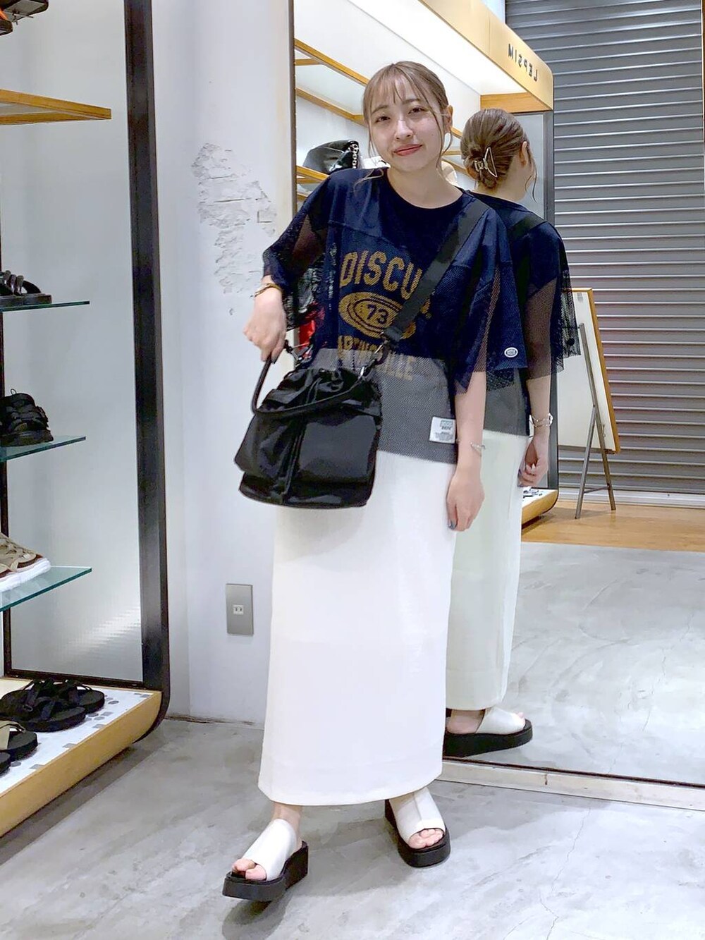 ブラック系のショルダーバッグ、ホワイト系のサンダル、ホワイト系のスカートを着用したレディースの夏コーディネートの4枚目の写真
