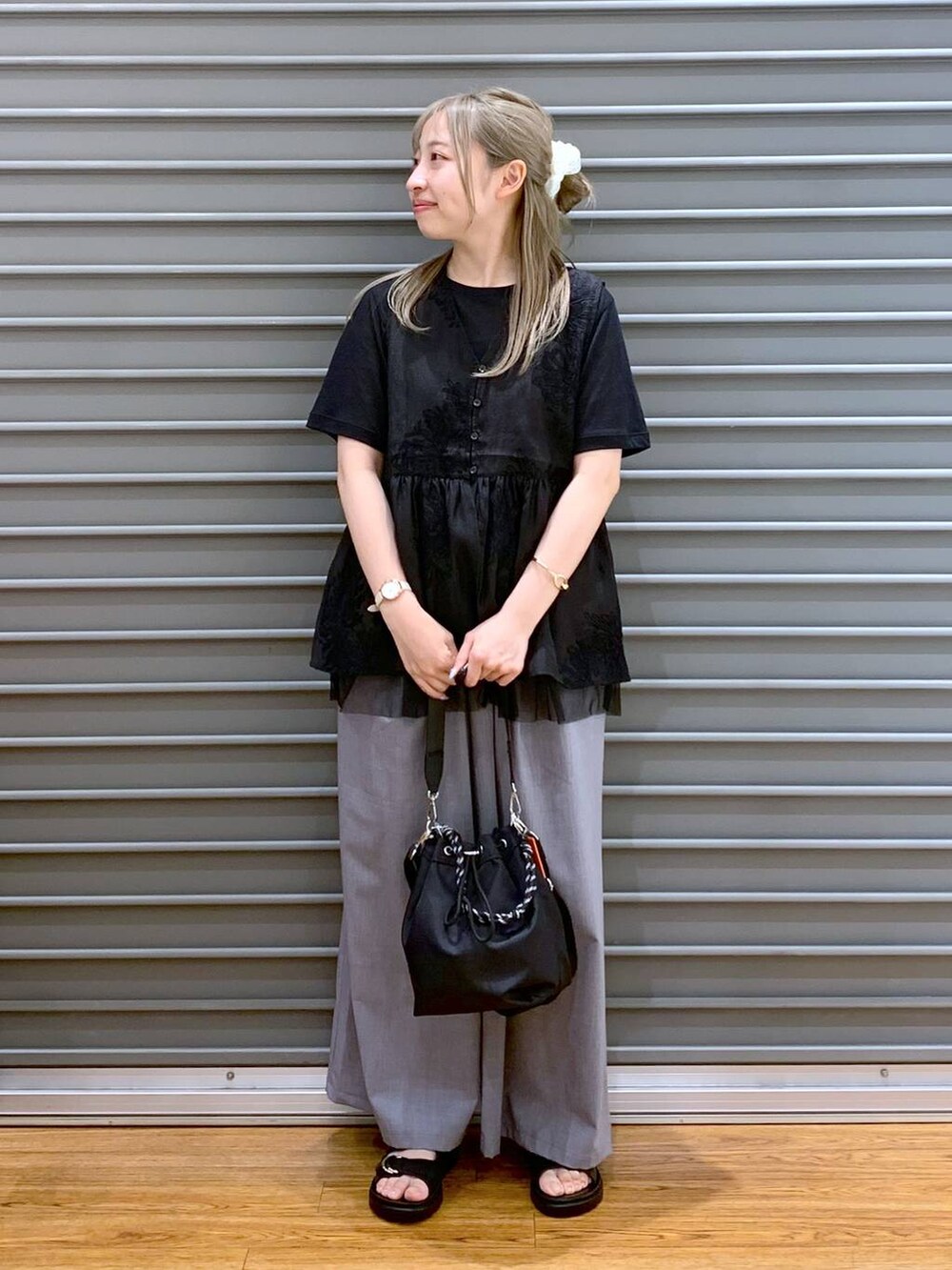 ブラック系のサンダル、グレー系のその他パンツ、ブラック系のショルダーバッグを着用したレディースの夏コーディネートの5枚目の写真