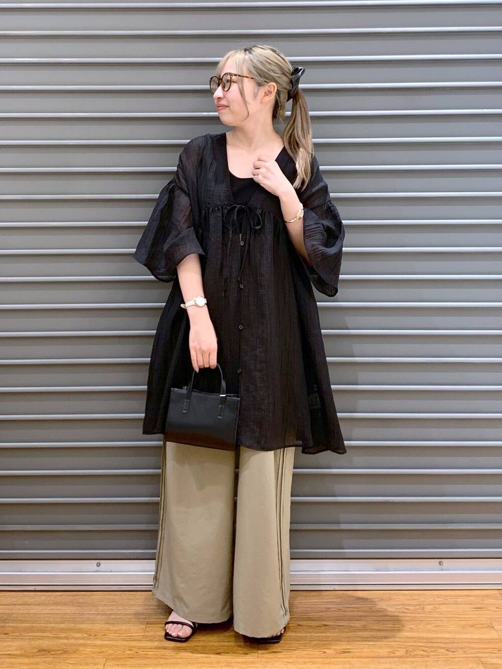 ブラック系のタンクトップ、ブラック系のショルダーバッグ、ベージュ系のその他パンツを着用したレディースの夏コーディネートの5枚目の写真