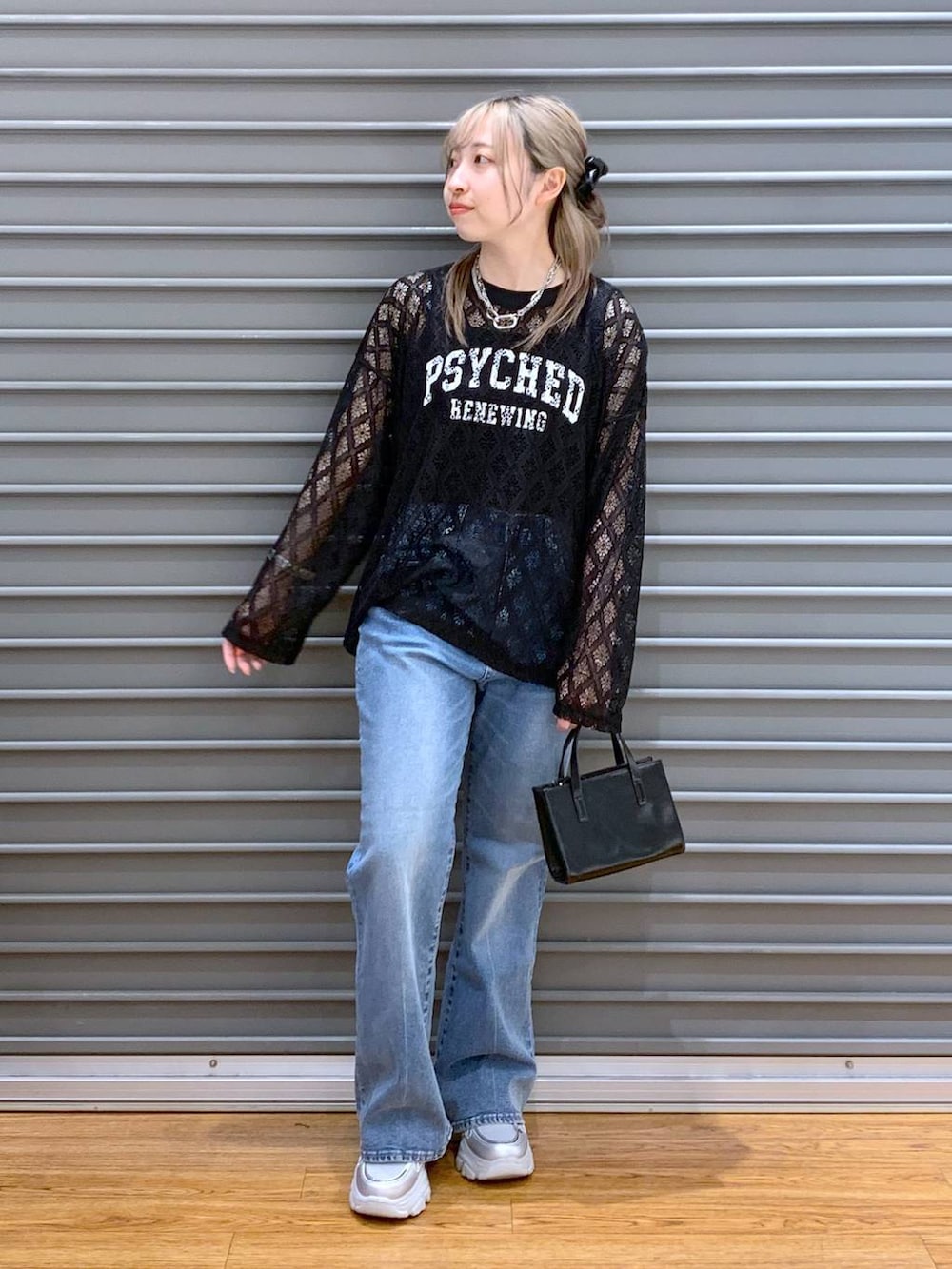 ブルー系のデニムパンツ、ブラック系のタンクトップ、シルバー系のスニーカーを着用したレディースの春コーディネートの7枚目の写真