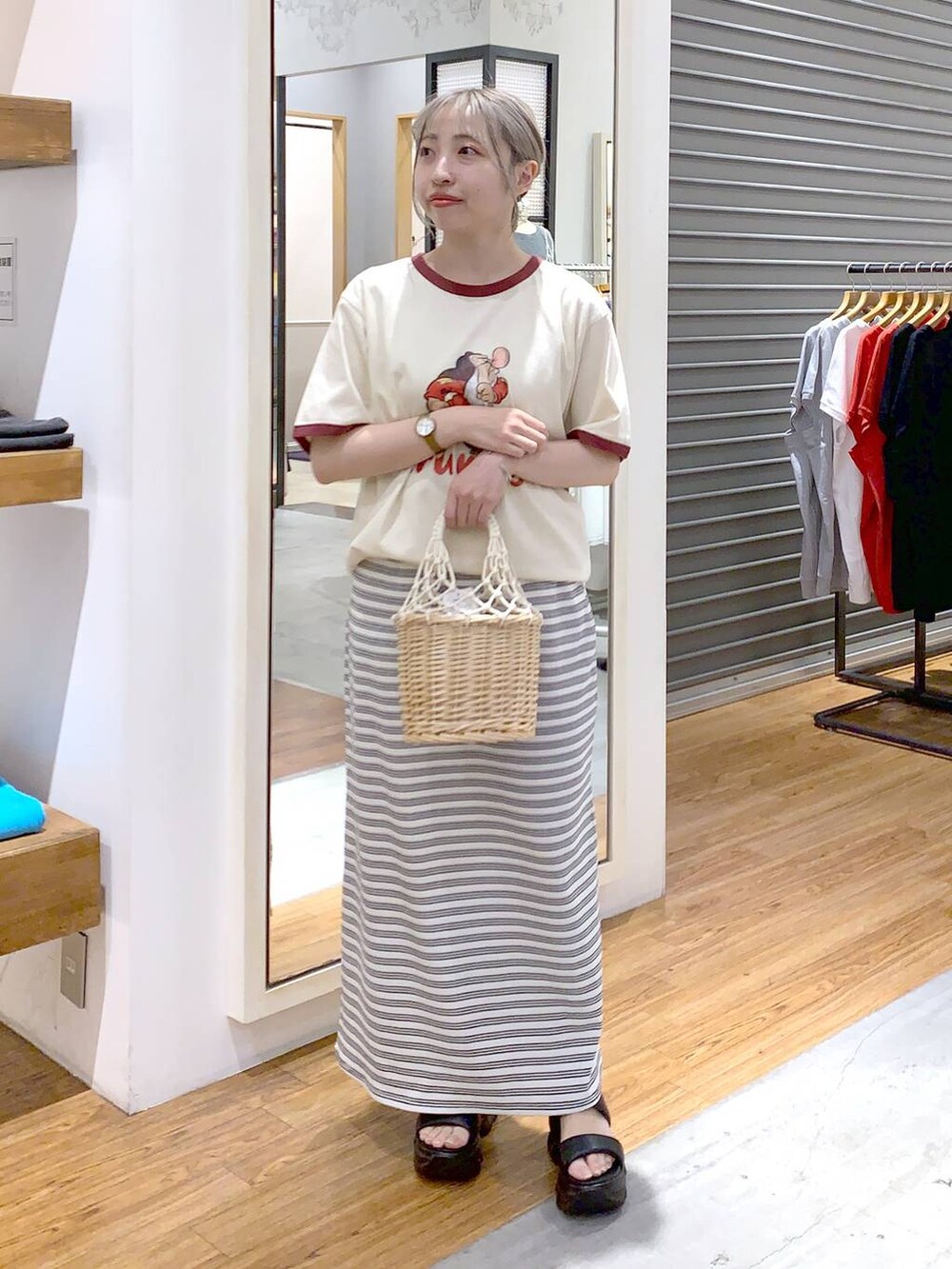 ブラック系のサンダル、ホワイト系のかごバッグ、ホワイト系のスカートを着用したレディースの夏コーディネートの3枚目の写真