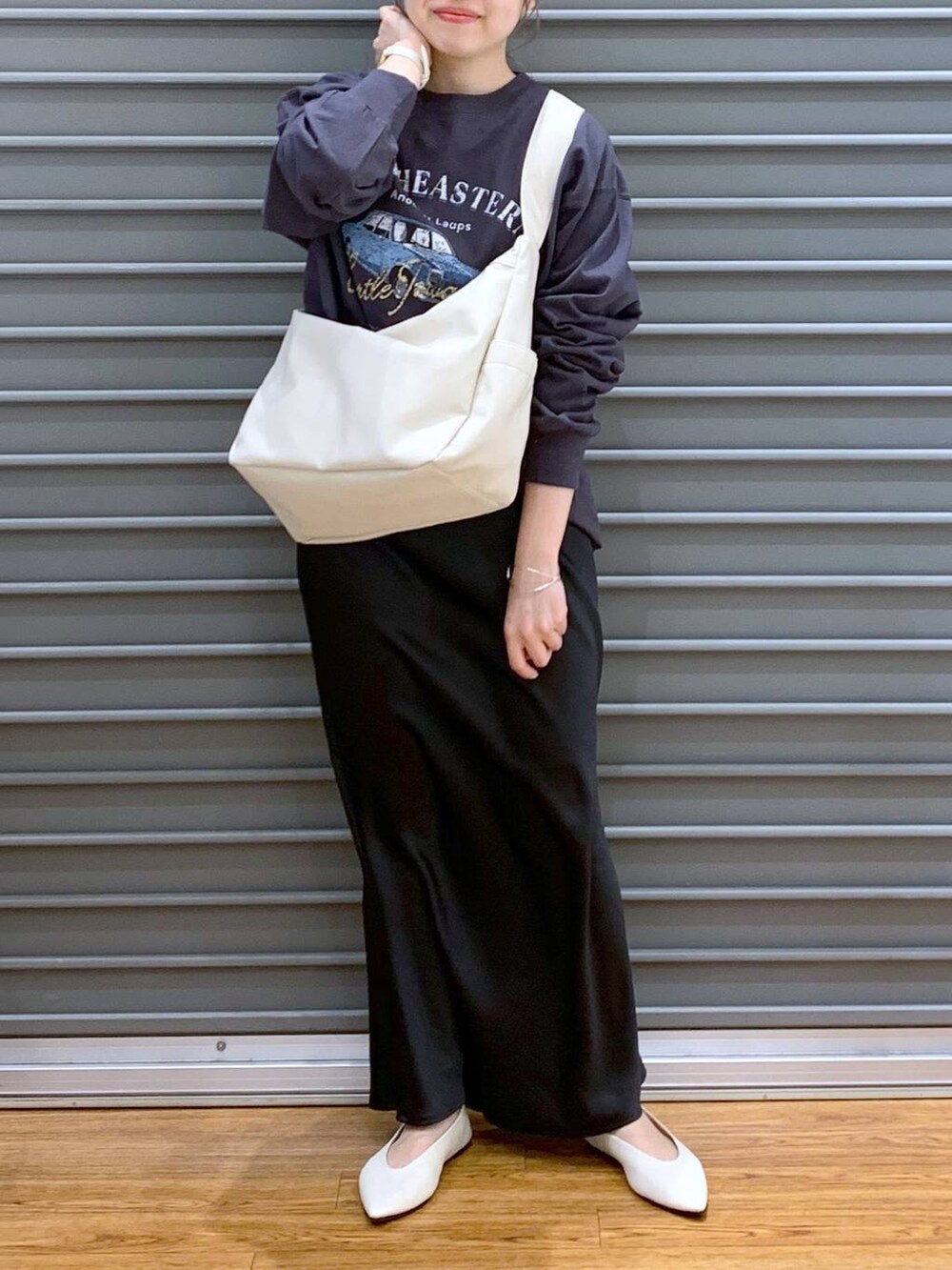 ブラック系のスカート、ホワイト系のパンプス、グレー系のTシャツ/カットソーを着用したレディースの春コーディネートの4枚目の写真