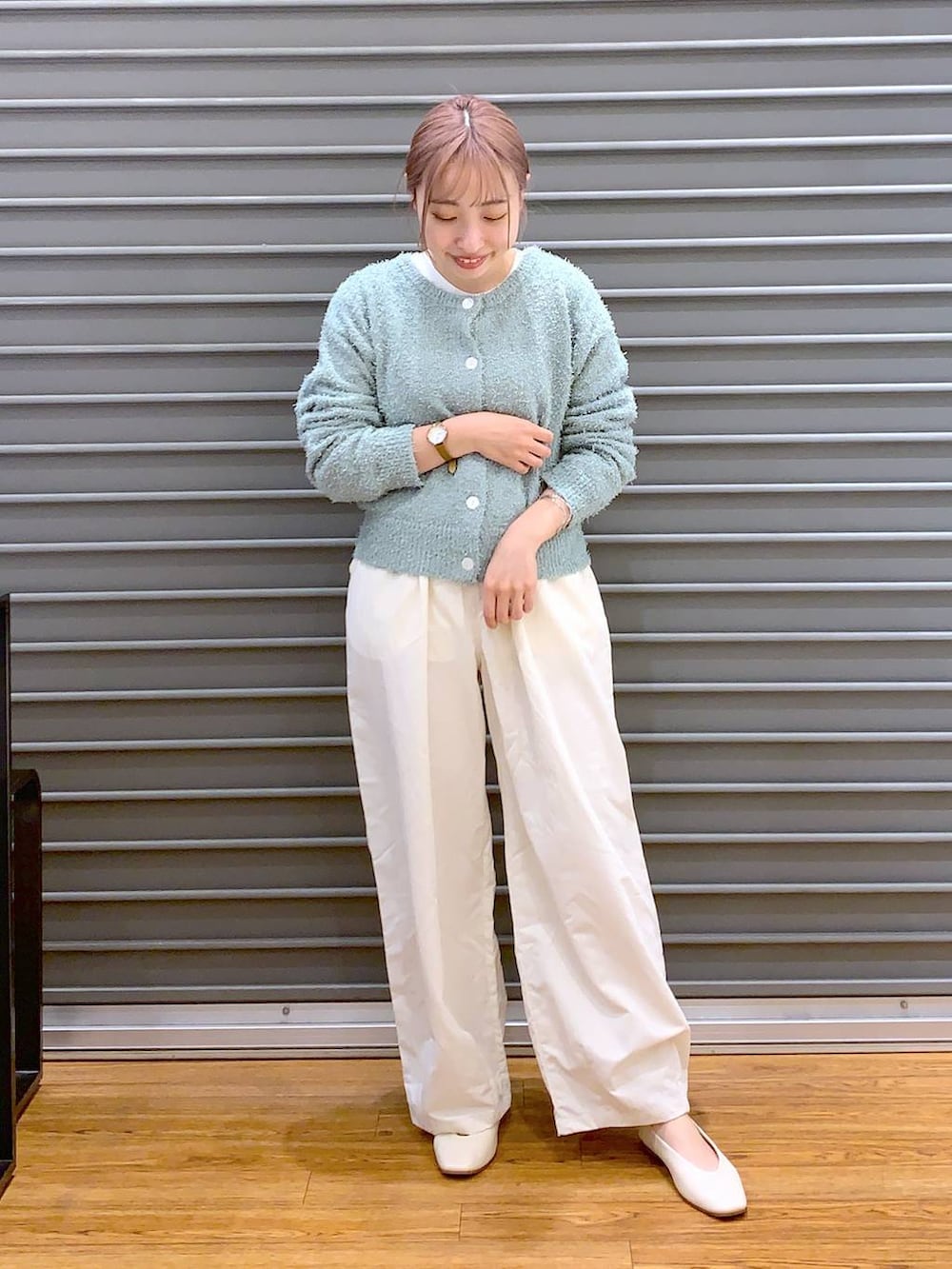 ホワイト系のショルダーバッグ、ホワイト系のパンプス、グリーン系のカーディガン/ボレロを着用したレディースの春コーディネートの3枚目の写真