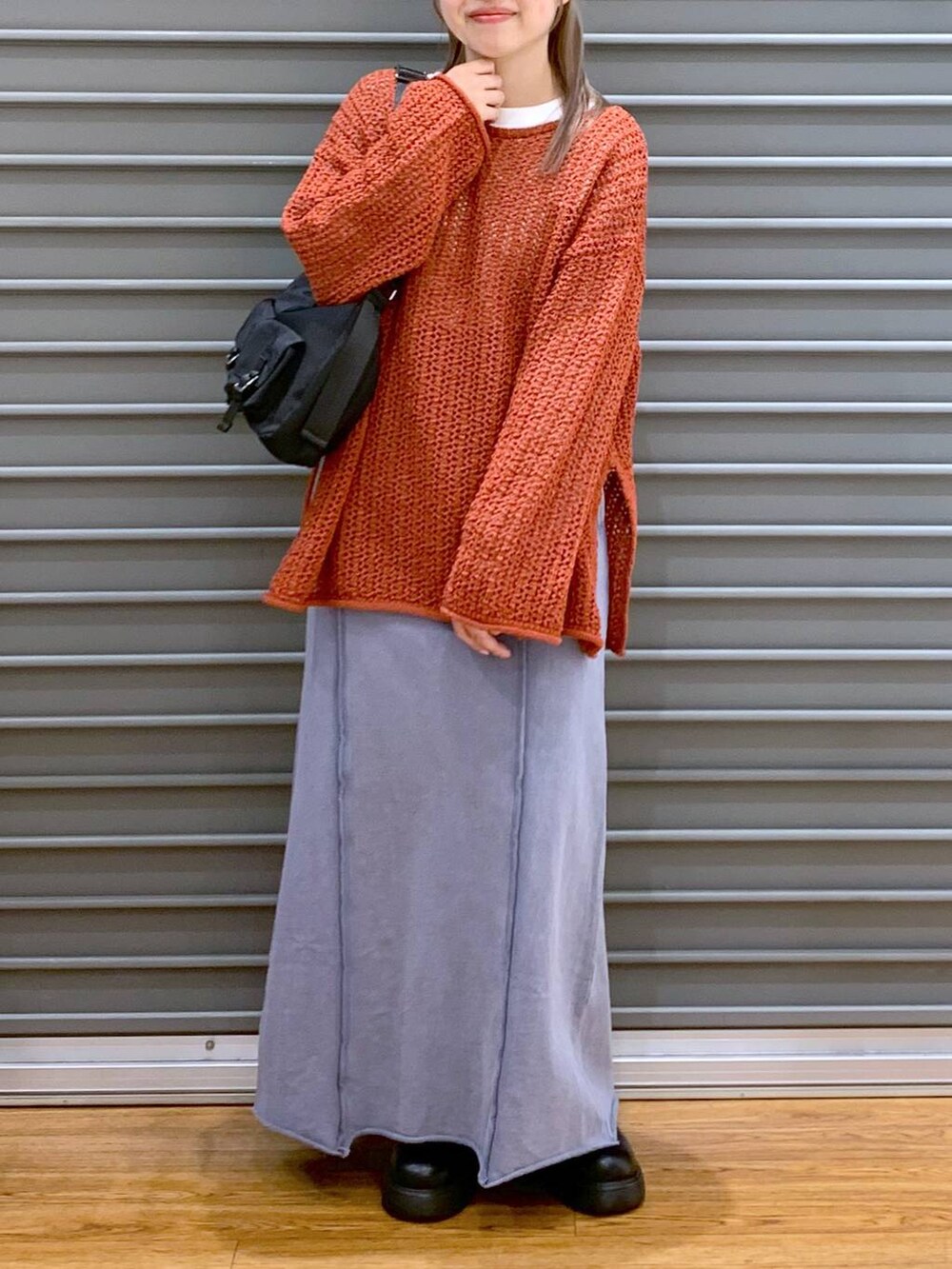 レッド系のニット/セーター、ブラック系のショルダーバッグ、ブラック系のサンダルを着用したレディースの春コーディネートの3枚目の写真