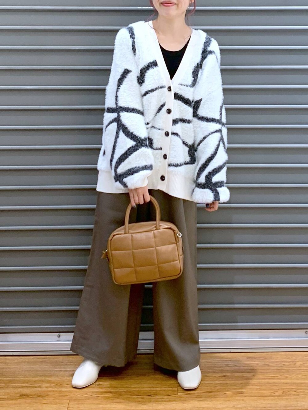 ホワイト系のカーディガン/ボレロ、ブラウン系のボストンバッグ、ブラウン系のその他パンツを着用したレディースの秋コーディネートの5枚目の写真