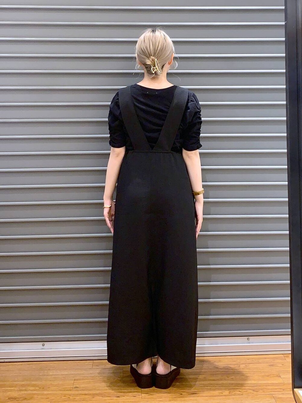 ホワイト系のショルダーバッグ、ホワイト系のサンダル、ブラック系のワンピースを着用したレディースの夏コーディネートの2枚目の写真