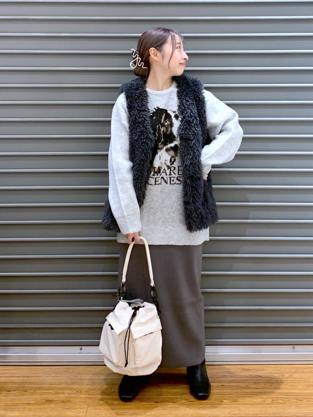 ホワイト系のショルダーバッグ、グレー系のスカート、ブラック系のブーツを着用したレディースの冬コーディネートの4枚目の写真