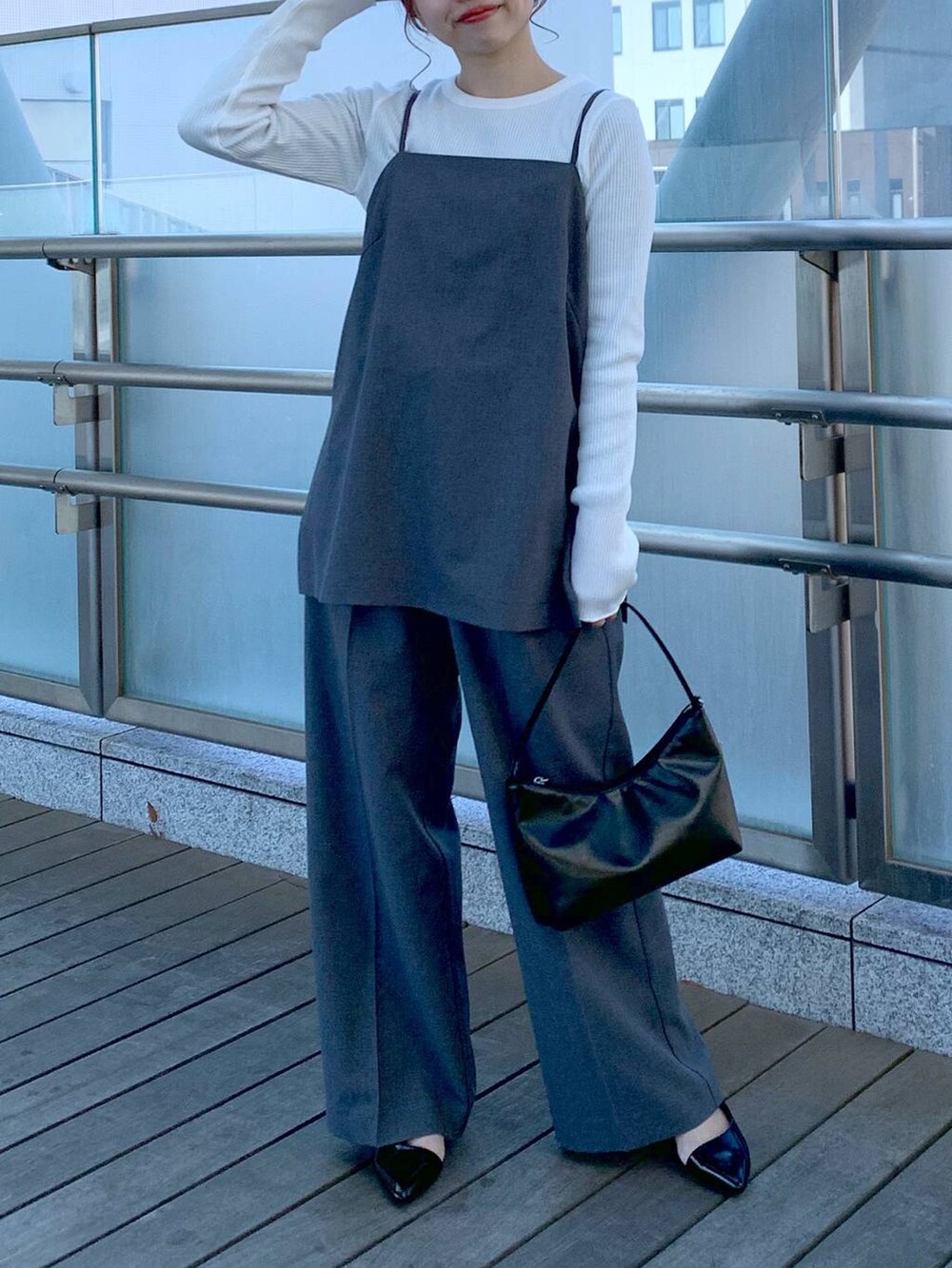 ブラック系のハンドバッグ、ホワイト系のTシャツ/カットソー、グレー系のキャミソールを着用したレディースの春コーディネートの3枚目の写真