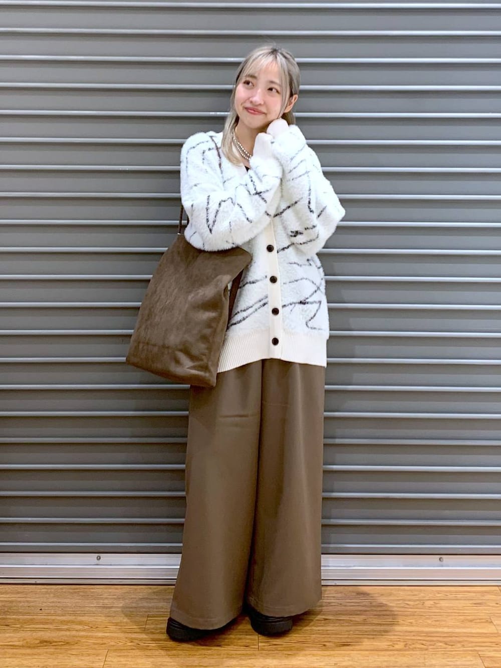 ブラウン系のその他パンツ、ホワイト系のカーディガン/ボレロ、ブラック系のブーツを着用したレディースの秋コーディネートの4枚目の写真