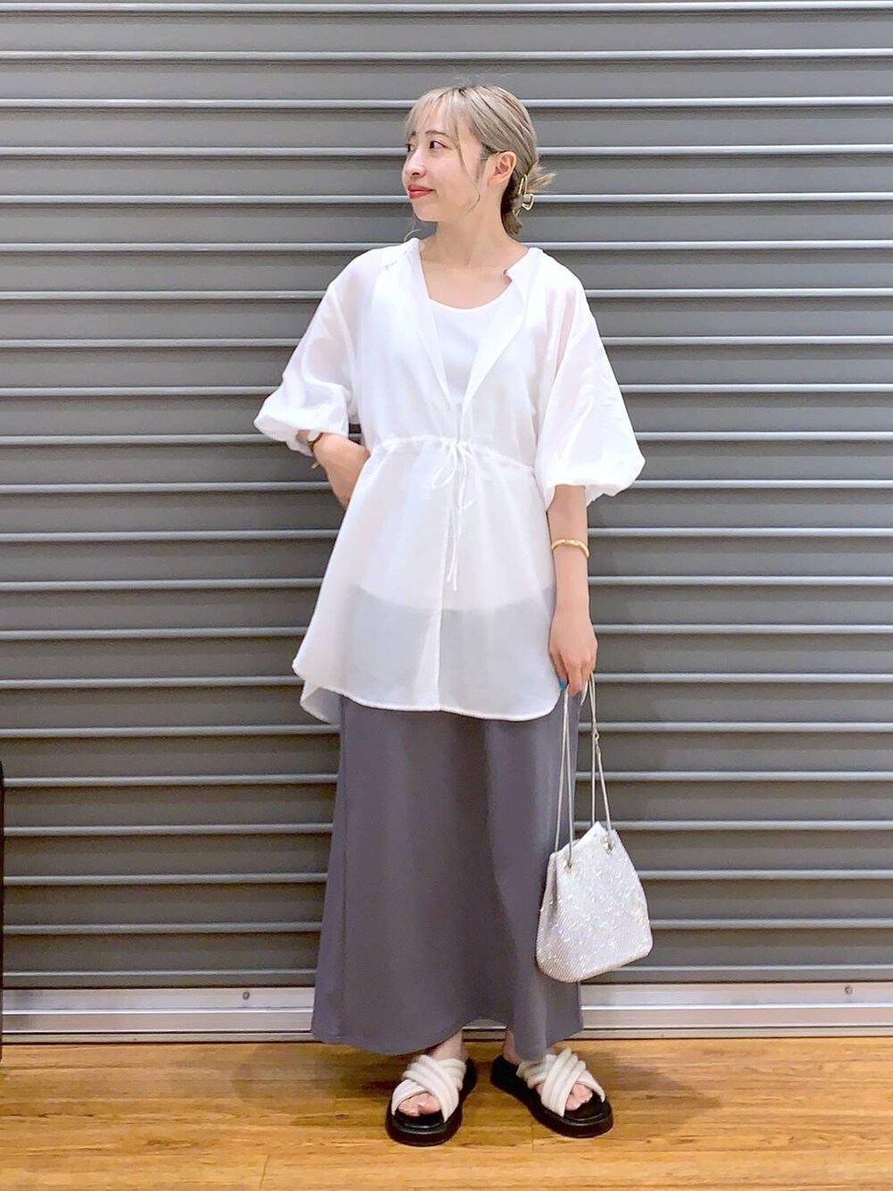 ホワイト系のショルダーバッグ、グレー系のスカート、ホワイト系のサンダルを着用したレディースの夏コーディネートの3枚目の写真