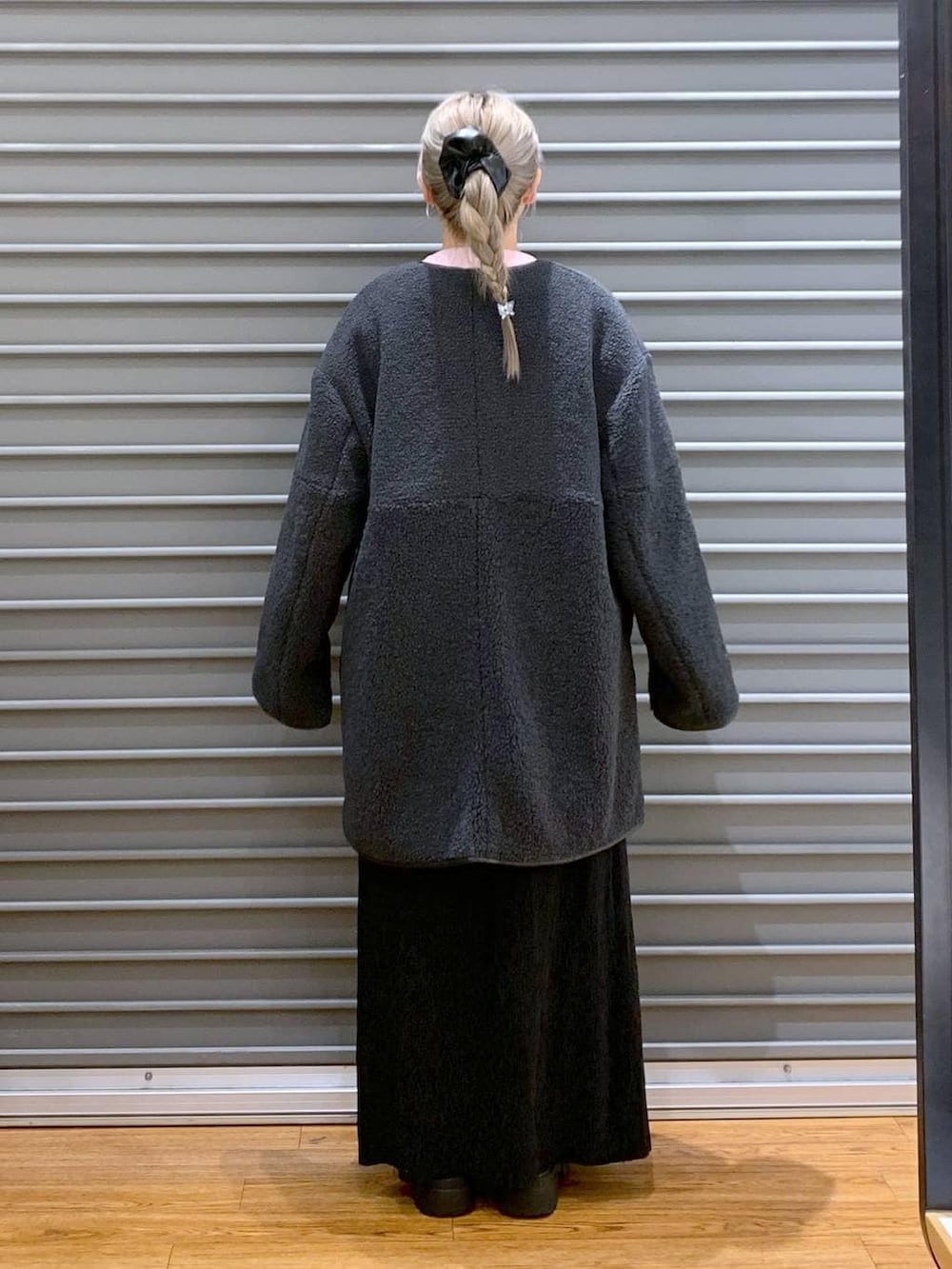 ブラック系のショルダーバッグ、グレー系のその他アウター、ブラック系のブーツを着用したレディースの冬コーディネートの2枚目の写真