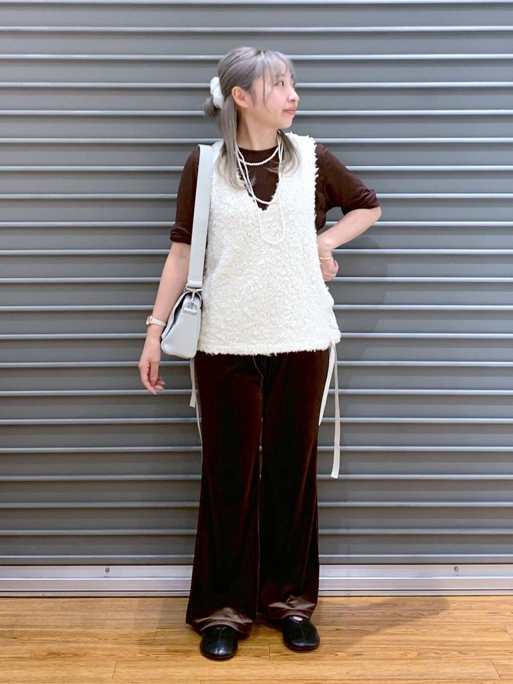 ブラウン系のその他パンツ、グレー系のショルダーバッグ、ホワイト系のベストを着用したレディースの秋コーディネートの4枚目の写真