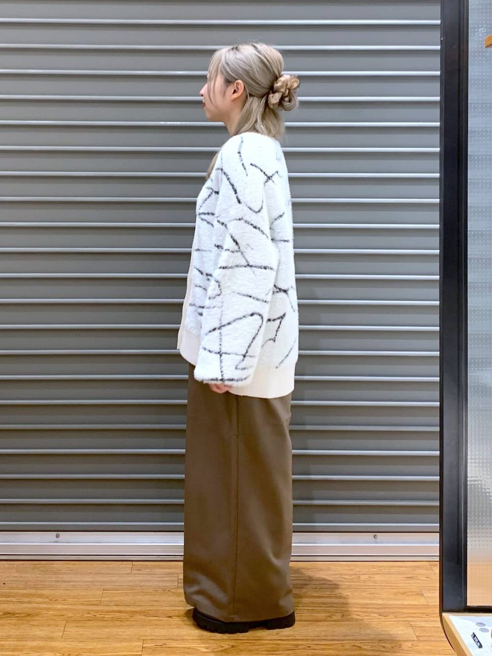 ブラウン系のその他パンツ、ホワイト系のカーディガン/ボレロ、ブラック系のブーツを着用したレディースの秋コーディネートの3枚目の写真
