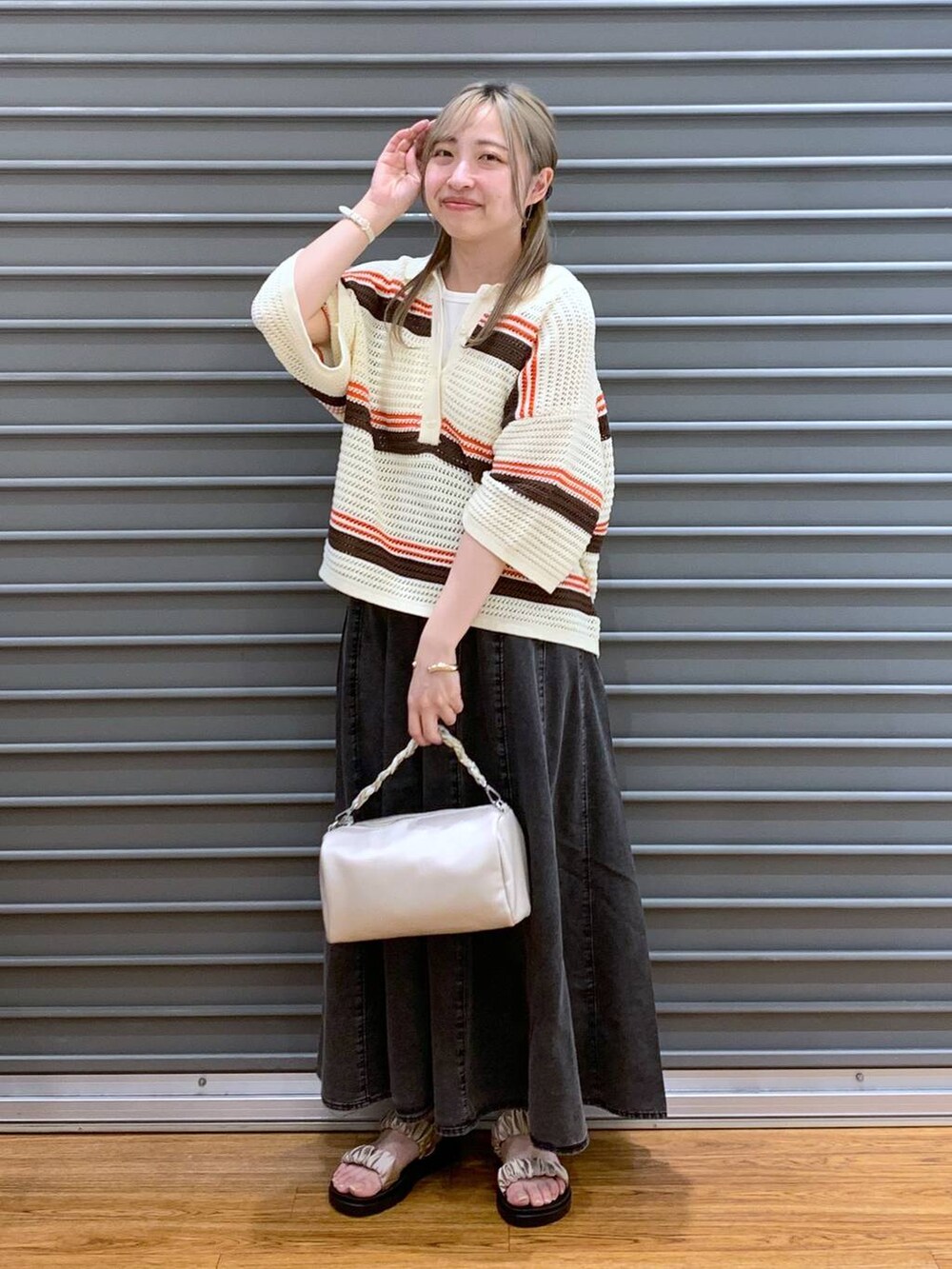 ベージュ系のサンダル、グレー系のスカート、ホワイト系のショルダーバッグを着用したレディースの春コーディネートの5枚目の写真
