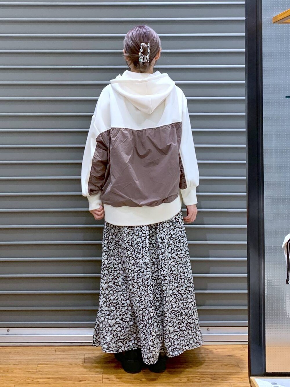 ホワイト系のショルダーバッグ、ブラック系のブーツ、ホワイト系のパーカーを着用したレディースの冬コーディネートの2枚目の写真