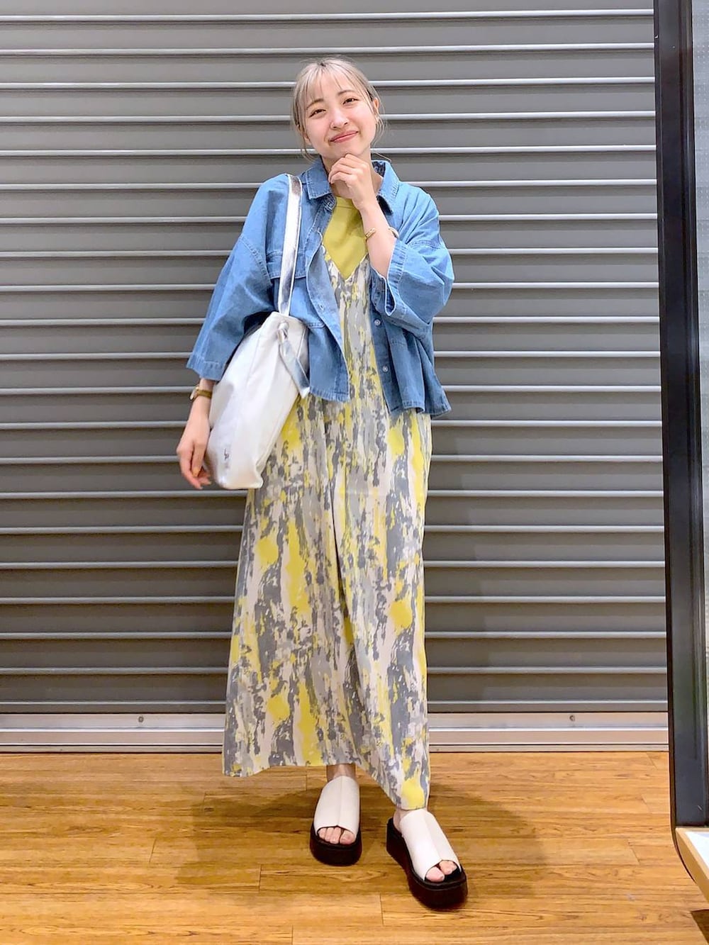 イエロー系のワンピース、ブルー系のシャツ/ブラウス、ホワイト系のサンダルを着用したレディースの夏コーディネートの3枚目の写真