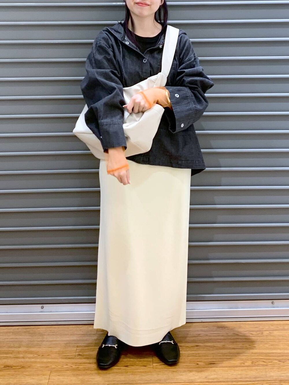 ブラック系のTシャツ/カットソー、ブラック系のローファー、ホワイト系のスカートを着用したレディースの春コーディネートの6枚目の写真