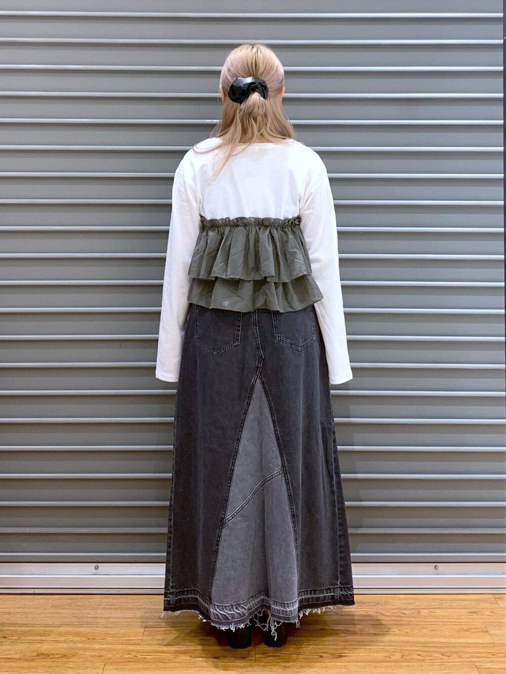 ブラック系のデニムスカート、グリーン系のTシャツ/カットソー、ブラック系のショルダーバッグを着用したレディースの秋コーディネートの2枚目の写真