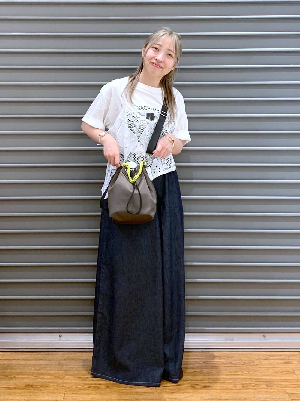 ブラック系のサンダル、ブルー系のデニムパンツ、ブラウン系のショルダーバッグを着用したレディースの夏コーディネートの7枚目の写真