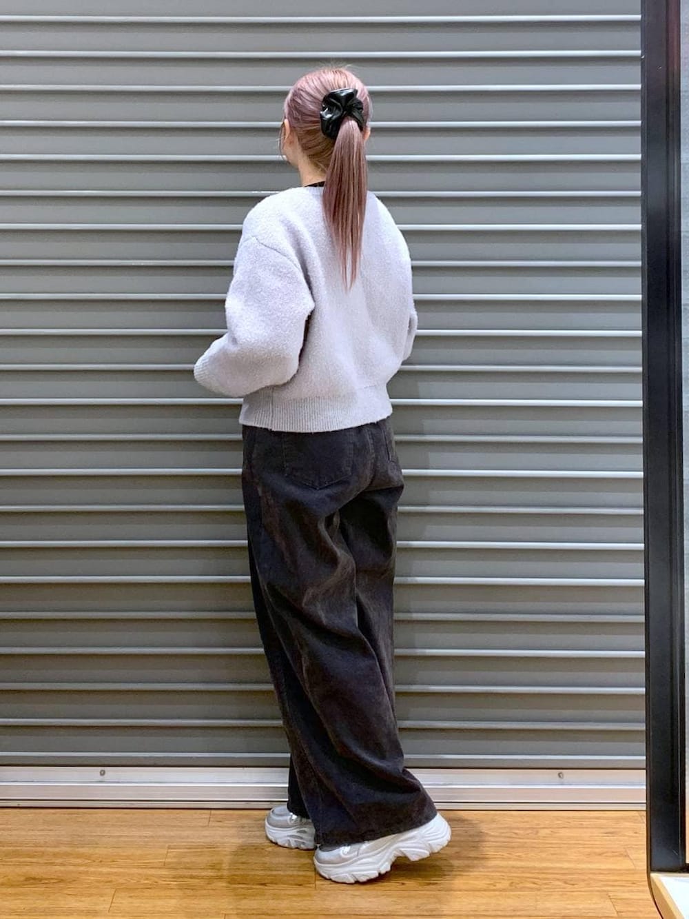 ブラック系のTシャツ/カットソー、ブラック系のショルダーバッグ、グレー系のデニムパンツを着用したレディースの冬コーディネートの3枚目の写真