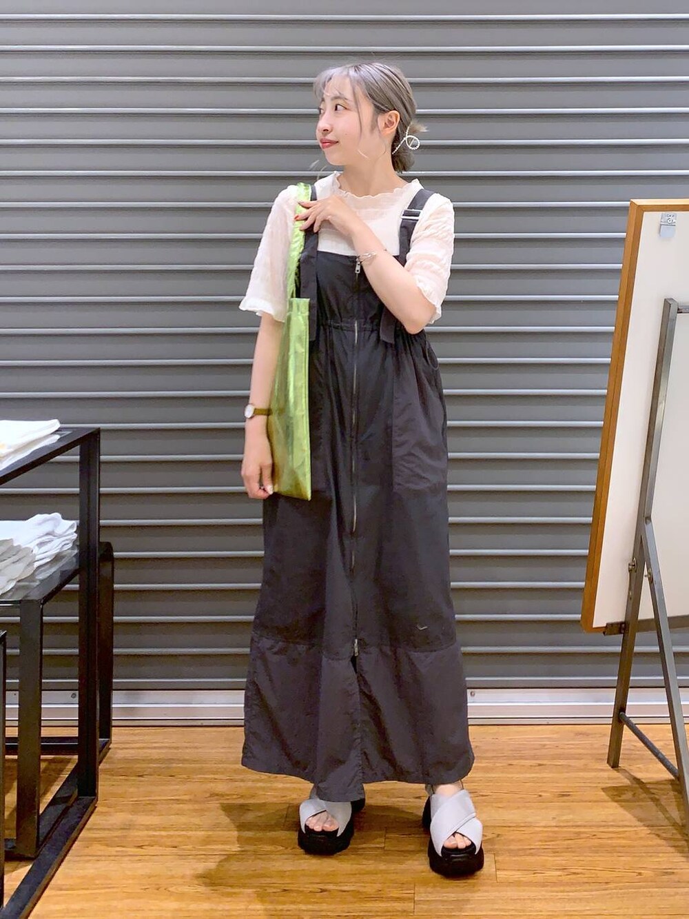 ホワイト系のTシャツ/カットソー、グリーン系のトートバッグ、ホワイト系のサンダルを着用したレディースの夏コーディネートの3枚目の写真