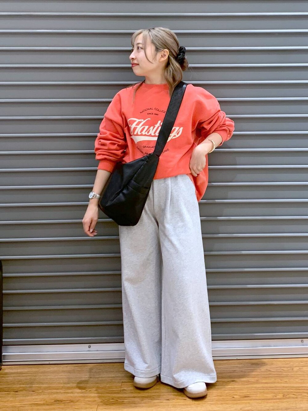 ホワイト系のスニーカー、ブラック系のショルダーバッグ、レッド系のスウェットを着用したレディースの冬コーディネートの7枚目の写真