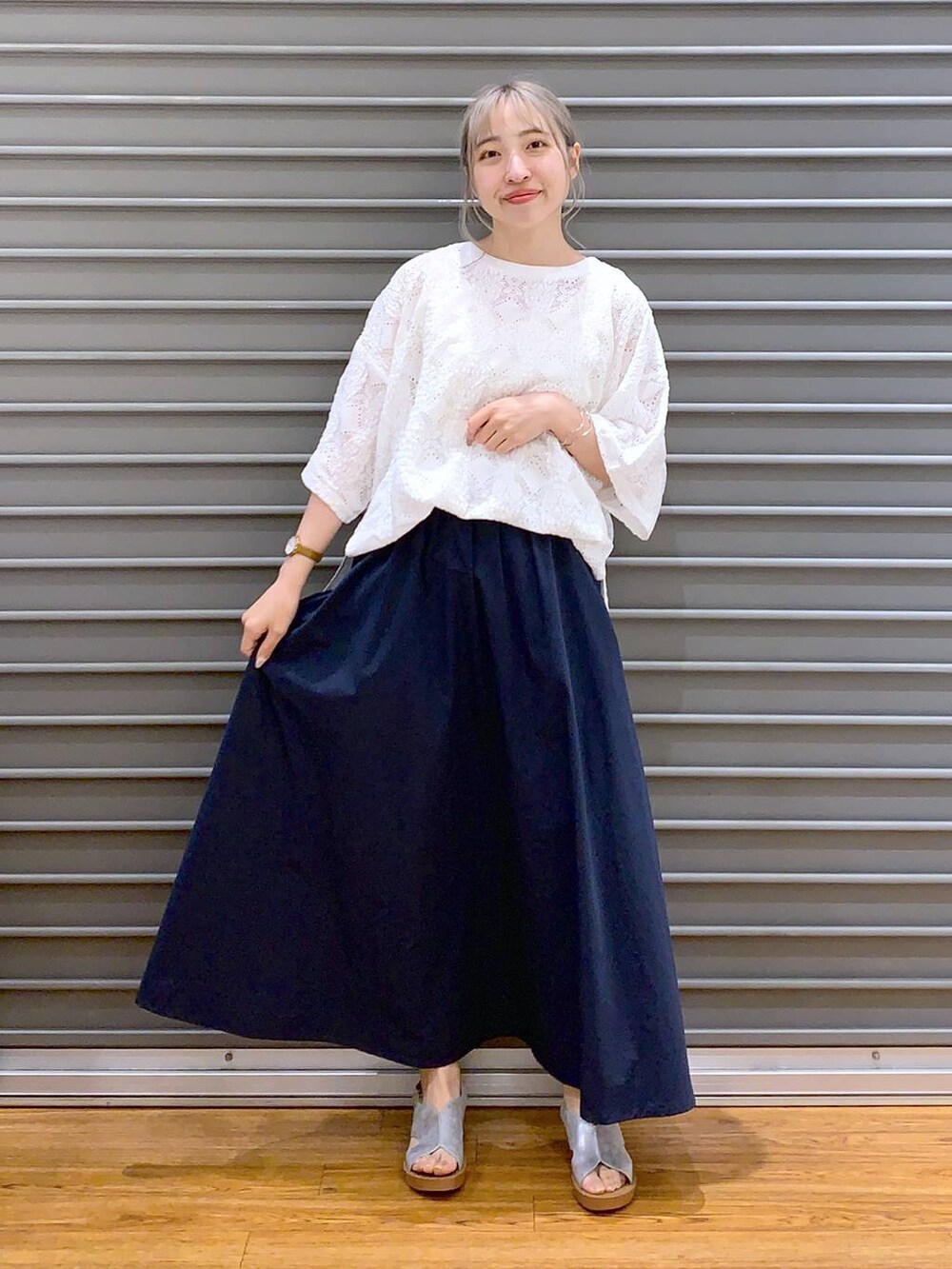 ブルー系のスカート、シルバー系のサンダル、ホワイト系のかごバッグを着用したレディースの夏コーディネートの5枚目の写真