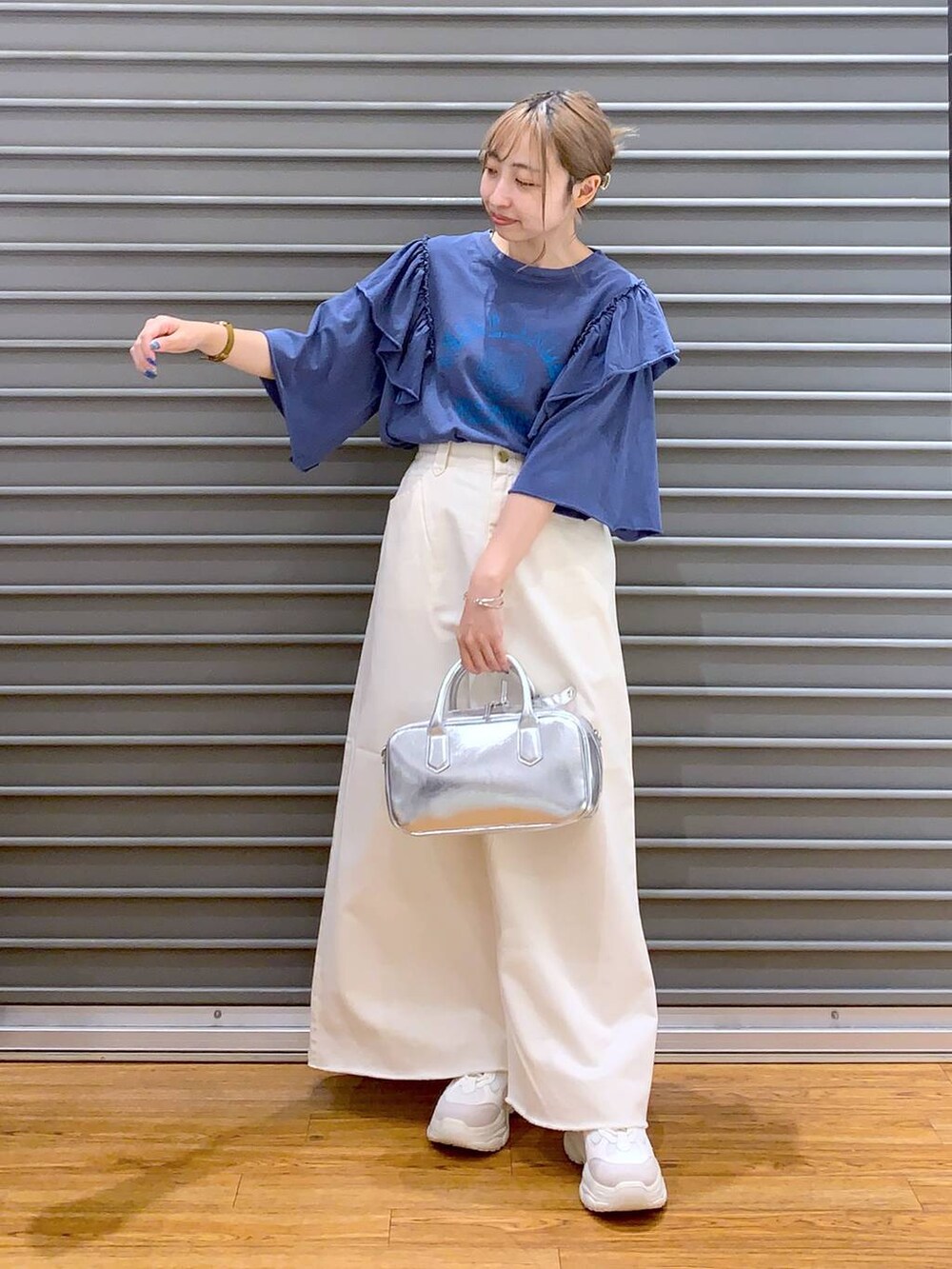 ホワイト系のスカート、ホワイト系のスニーカー、シルバー系のボストンバッグを着用したレディースの夏コーディネートの5枚目の写真