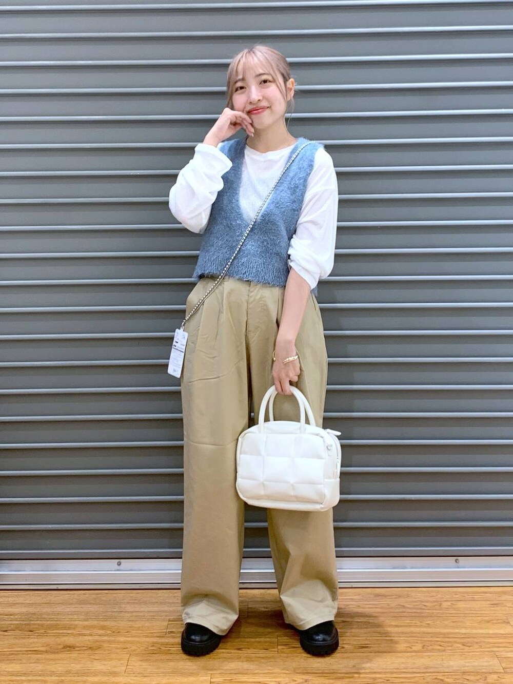 ホワイト系のTシャツ/カットソー、ブラック系のブーツ、ブルー系のベストを着用したレディースの秋コーディネートの4枚目の写真
