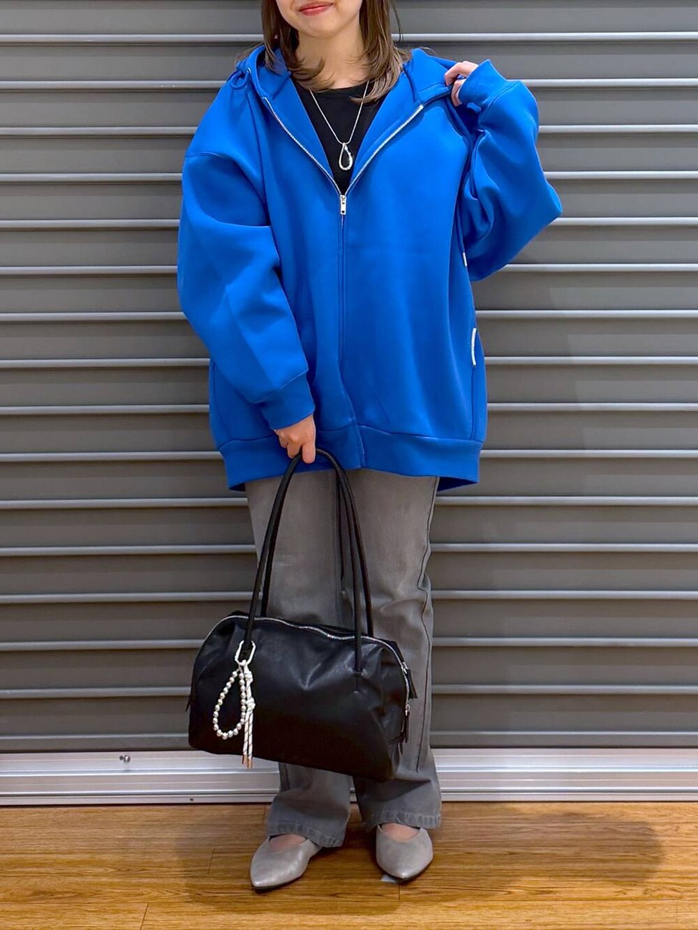 ブルー系のパーカー、ブラック系のTシャツ/カットソー、シルバー系のパンプスを着用したレディースの春コーディネートの6枚目の写真