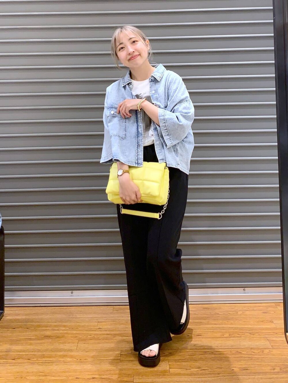 イエロー系のショルダーバッグ、ブルー系のシャツ/ブラウス、ホワイト系のサンダルを着用したレディースの春コーディネートの5枚目の写真