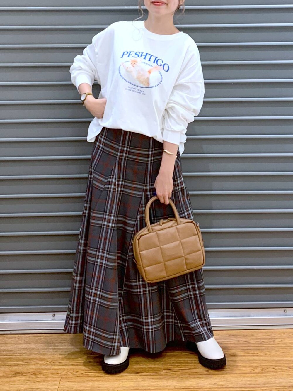 ホワイト系のブーツ、ブラウン系のボストンバッグ、グレー系のスカートを着用したレディースの秋コーディネートの5枚目の写真