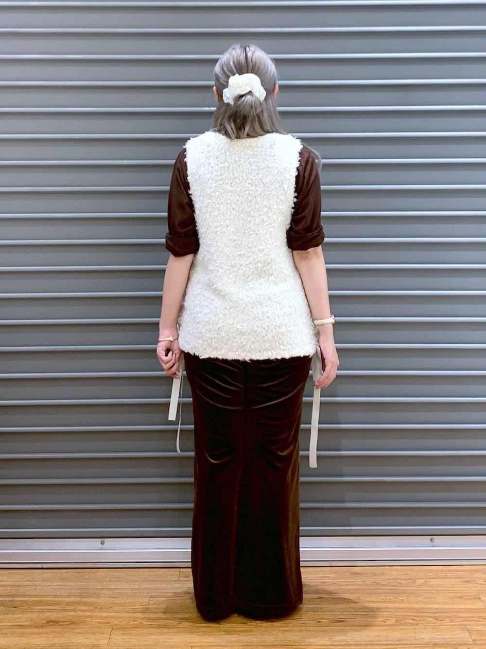 ブラウン系のその他パンツ、グレー系のショルダーバッグ、ホワイト系のベストを着用したレディースの秋コーディネートの2枚目の写真