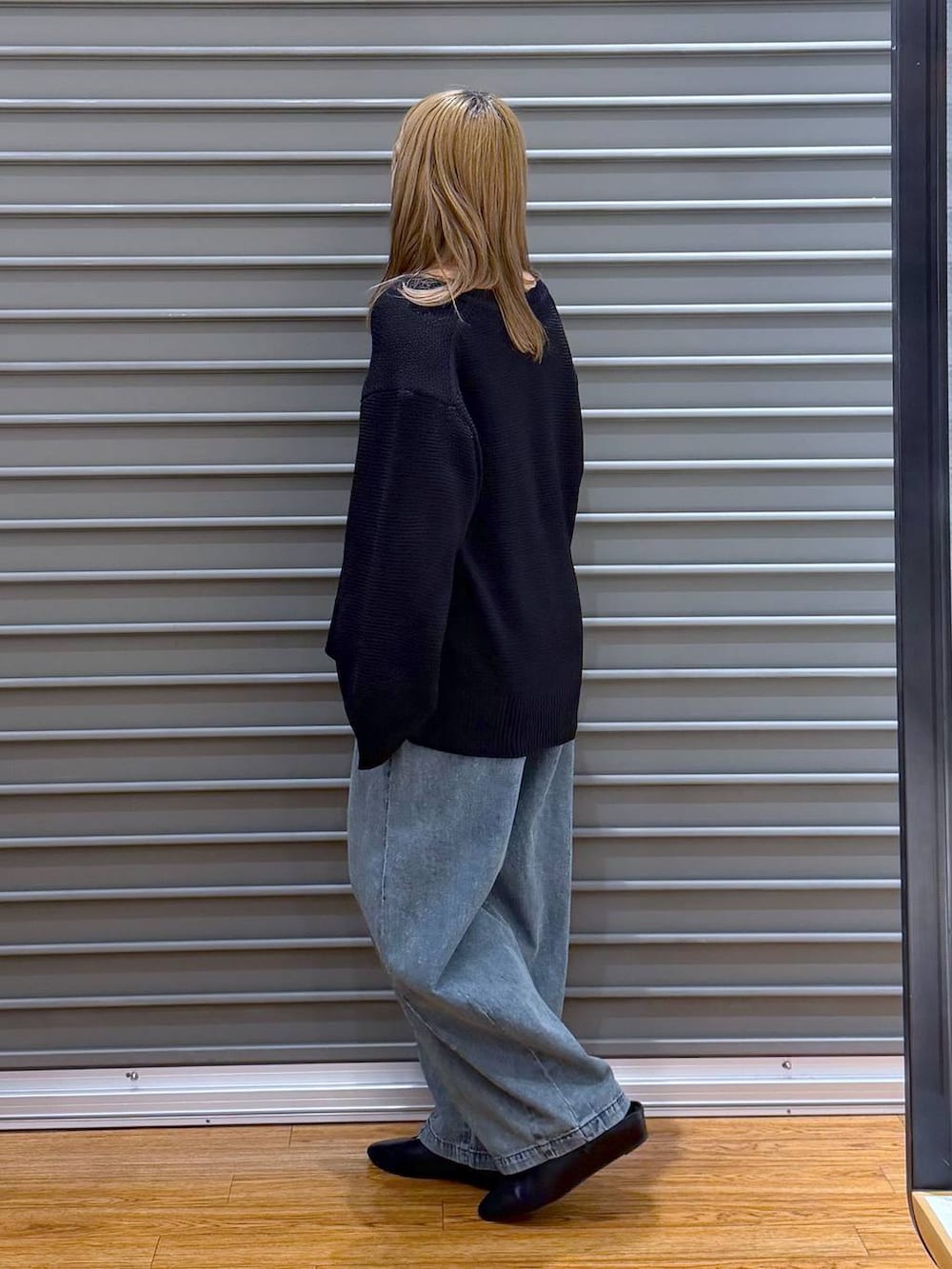 ブラック系のボストンバッグ、ブラック系のパンプス、ブルー系のデニムパンツを着用したレディースの春コーディネートの3枚目の写真