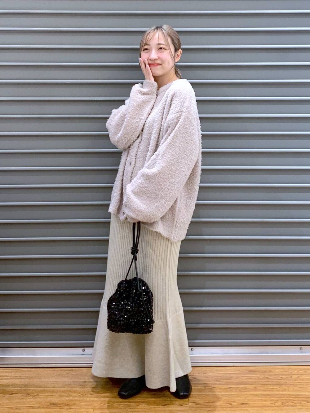 ブラック系のショルダーバッグ、ブラック系のブーツ、ホワイト系のワンピースを着用したレディースの冬コーディネートの5枚目の写真