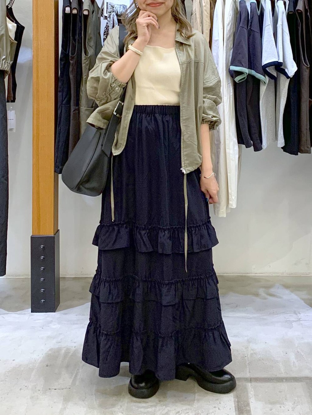 ホワイト系のタンクトップ、ブルー系のスカート、グレー系のショルダーバッグを着用したレディースの秋コーディネートの6枚目の写真