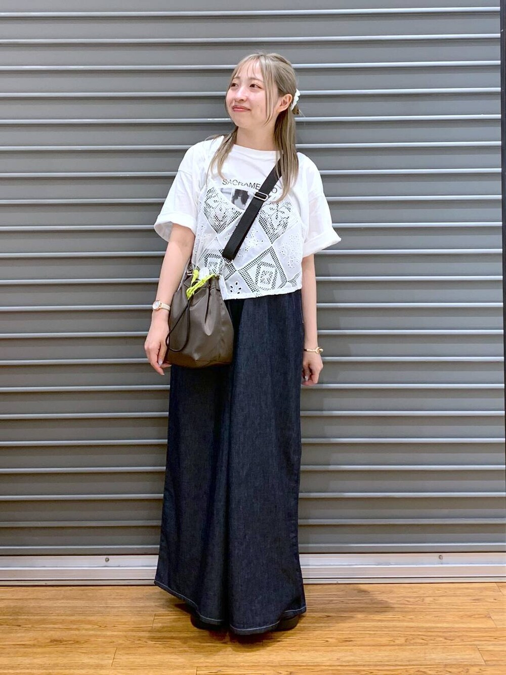 ブラック系のサンダル、ブルー系のデニムパンツ、ブラウン系のショルダーバッグを着用したレディースの夏コーディネートの6枚目の写真