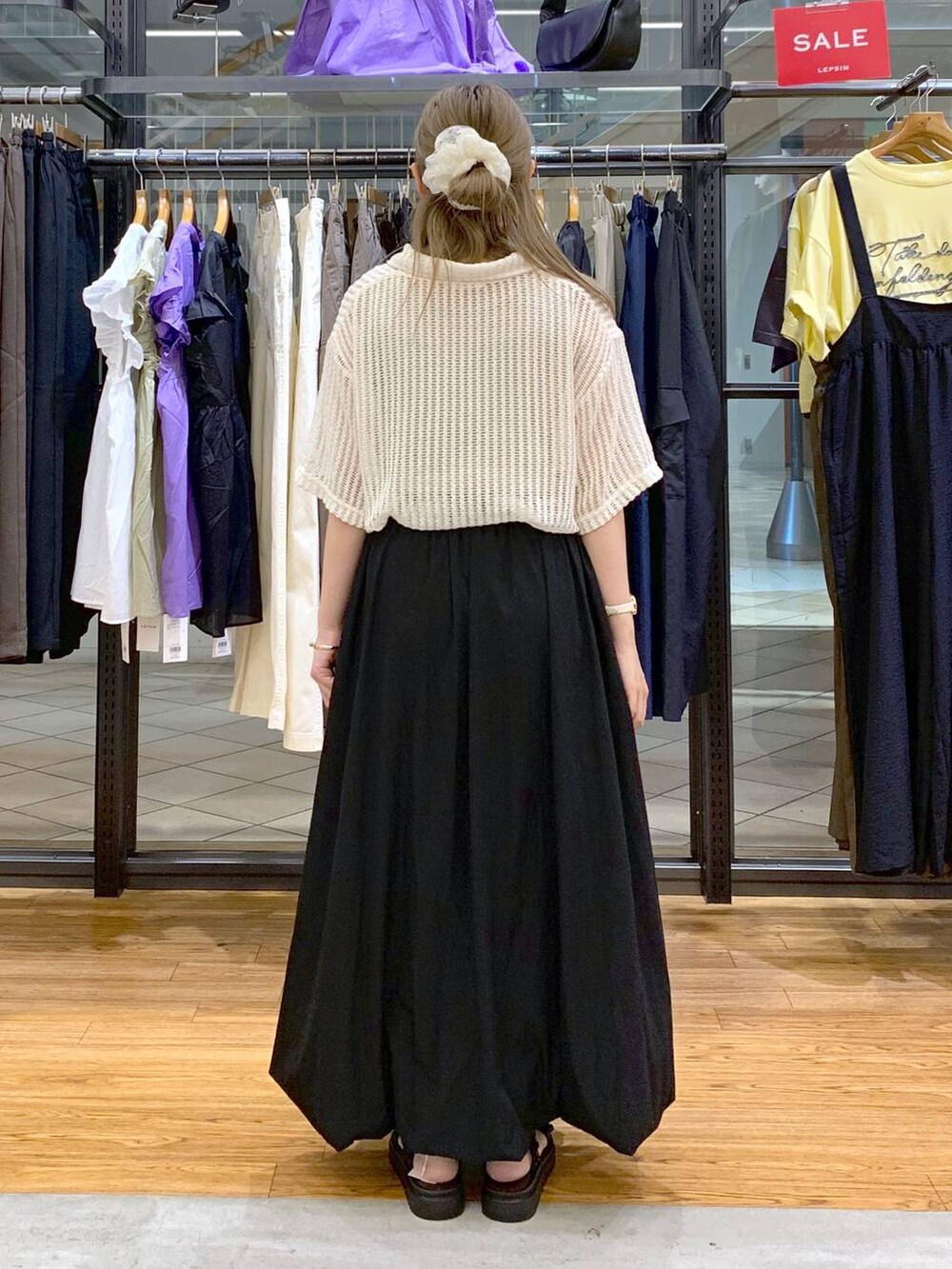 ブラック系のサンダル、ブラック系のスカート、ホワイト系のポロシャツを着用したレディースの夏コーディネートの2枚目の写真