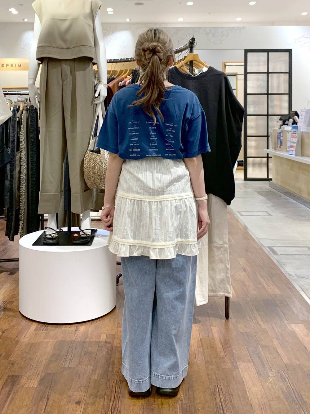 ブルー系のデニムパンツ、ブラック系のサンダル、ブラック系のショルダーバッグを着用したレディースの夏コーディネートの2枚目の写真