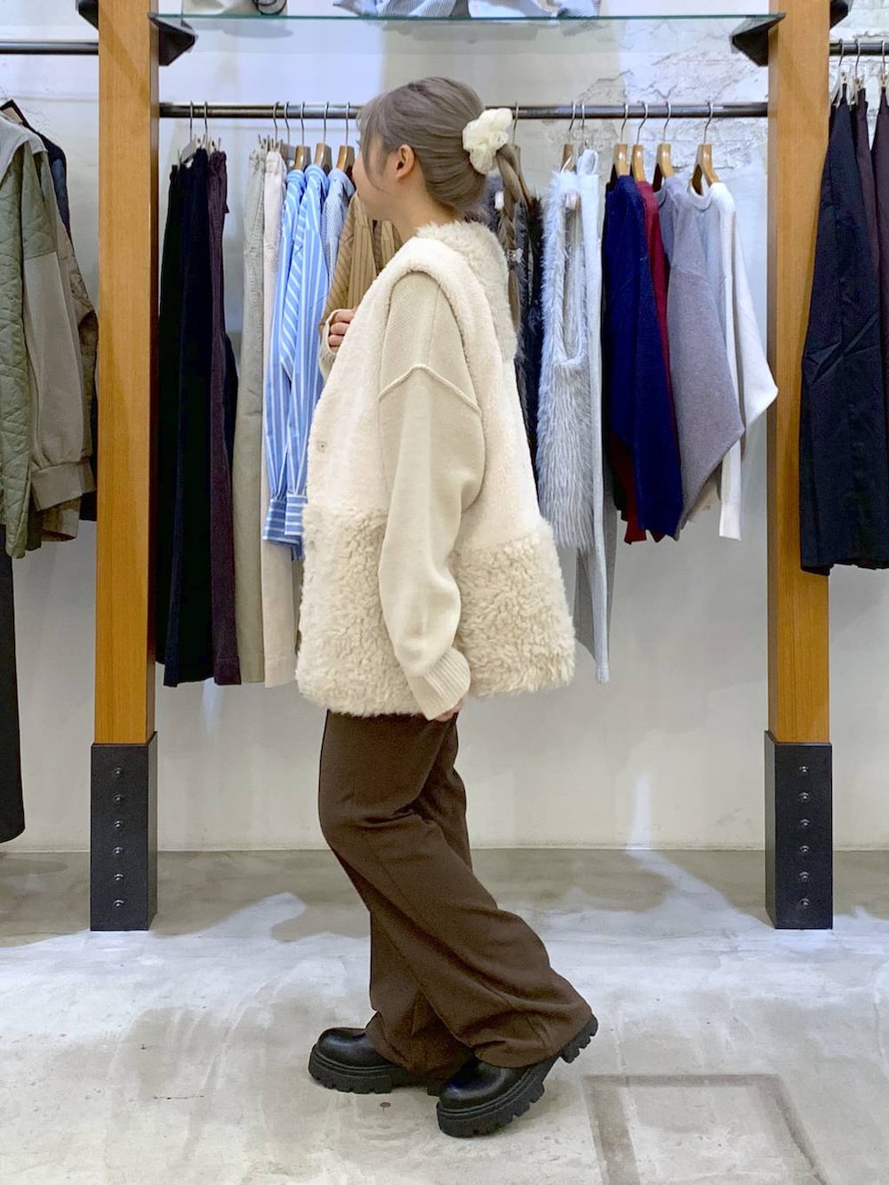 ブラウン系のその他パンツ、ブラック系のボストンバッグ、ホワイト系のベストを着用したレディースの秋コーディネートの4枚目の写真