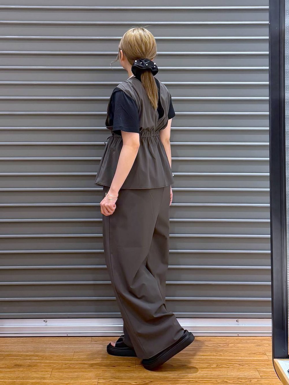 ブラック系のTシャツ/カットソー、グレー系のショルダーバッグ、ブラック系のサンダルを着用したレディースの春コーディネートの3枚目の写真