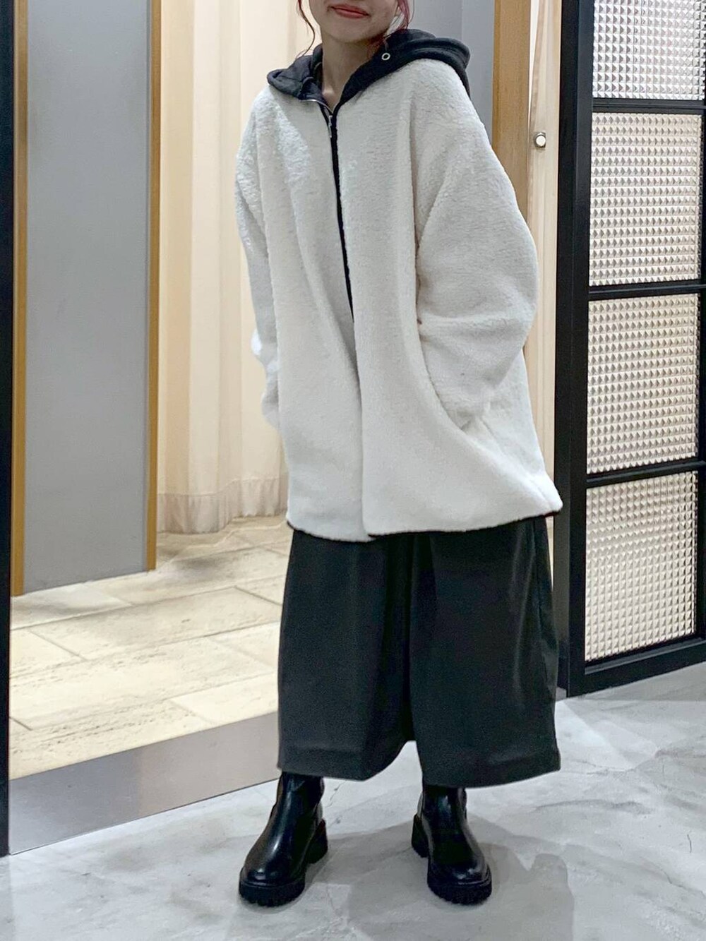 ブラック系のブーツ、ホワイト系のその他アウター、グレー系のワンピースを着用したレディースの秋コーディネートの5枚目の写真