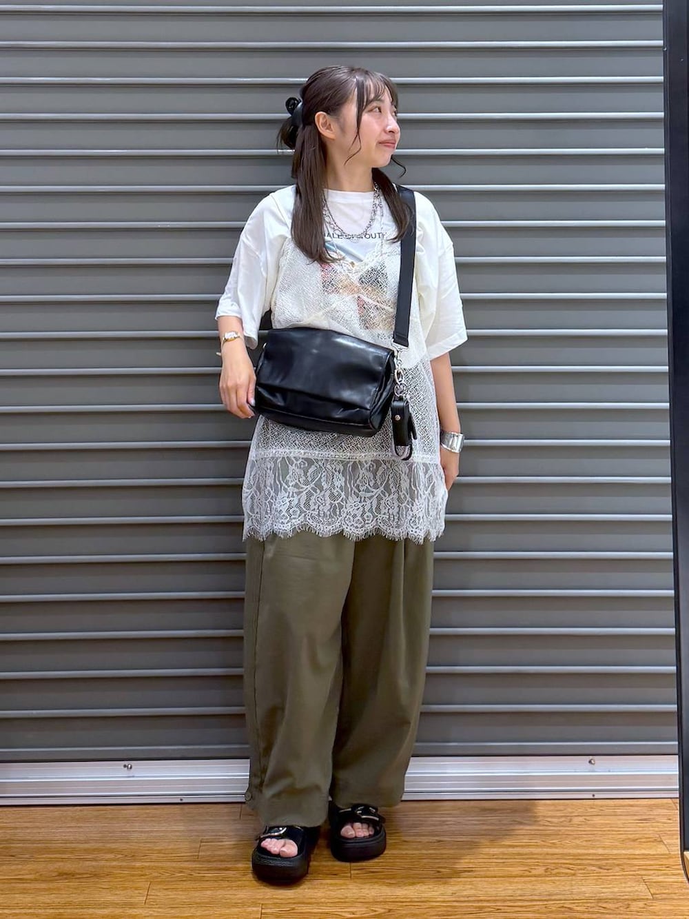 ホワイト系のTシャツ/カットソー、ブラック系のショルダーバッグ、ブラック系のサンダルを着用したレディースの夏コーディネートの5枚目の写真