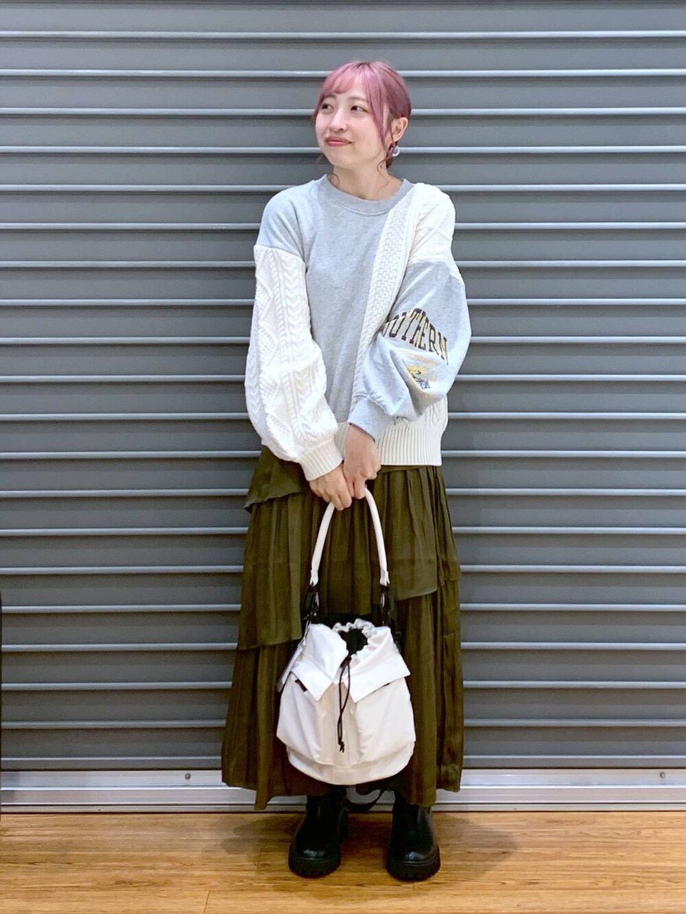 ホワイト系のショルダーバッグ、ブラック系のブーツ、グレー系のニット/セーターを着用したレディースの秋コーディネートの3枚目の写真