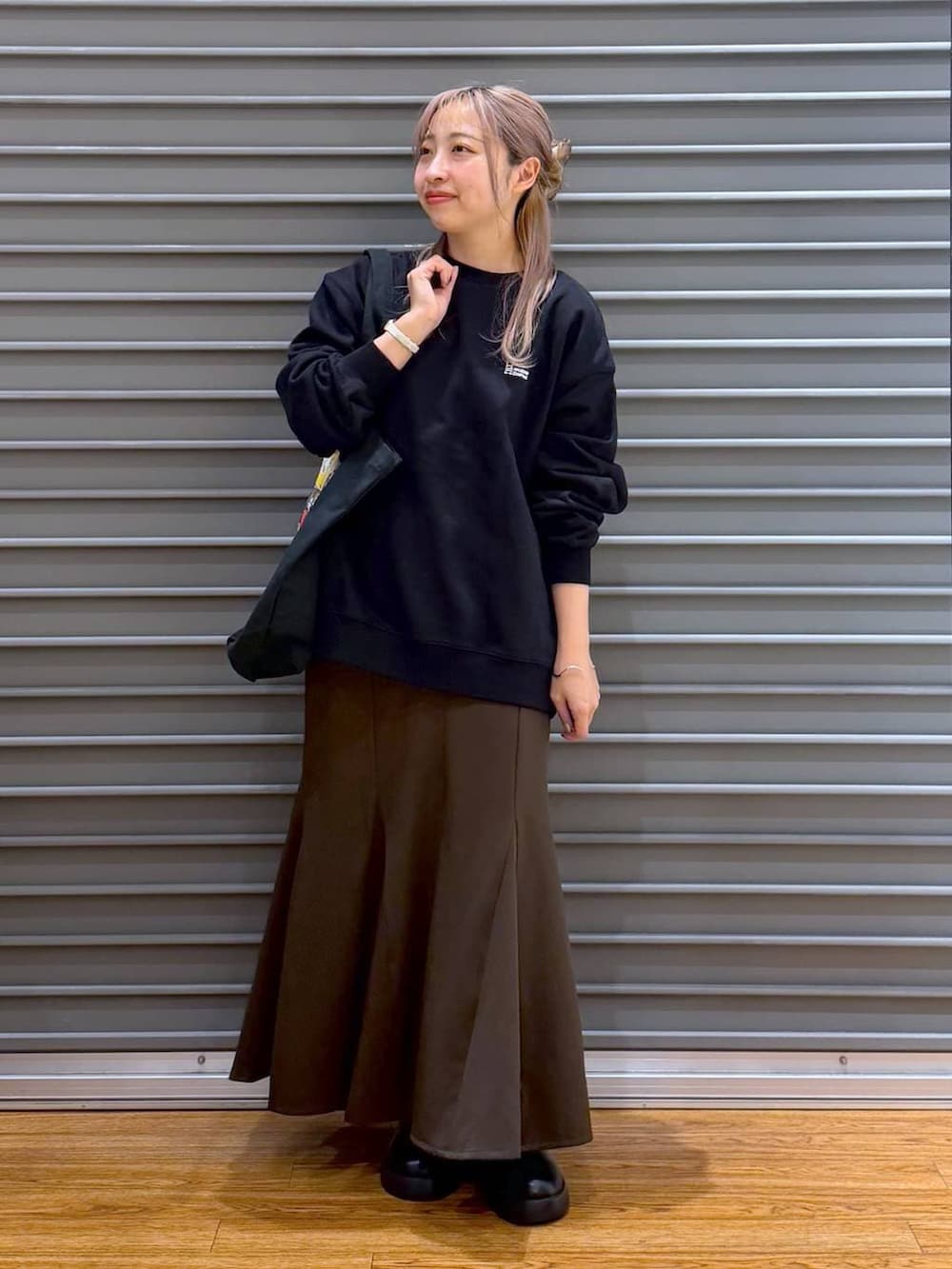 ブラック系のサンダル、ブラウン系のスカート、ブラック系のスウェットを着用したレディースの冬コーディネートの4枚目の写真