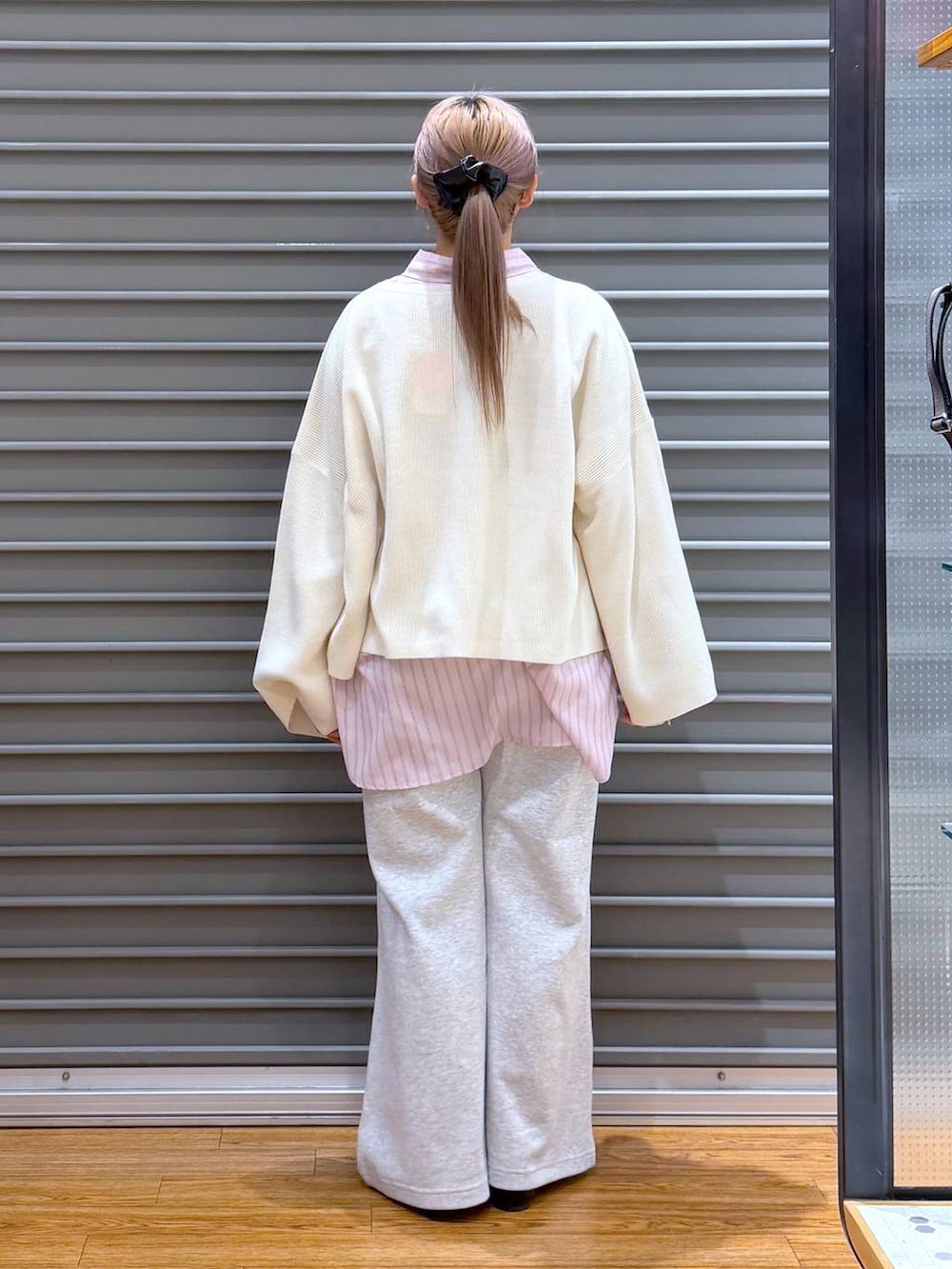 ホワイト系のニット/セーター、ブラック系のボストンバッグ、ブラック系のパンプスを着用したレディースの冬コーディネートの2枚目の写真