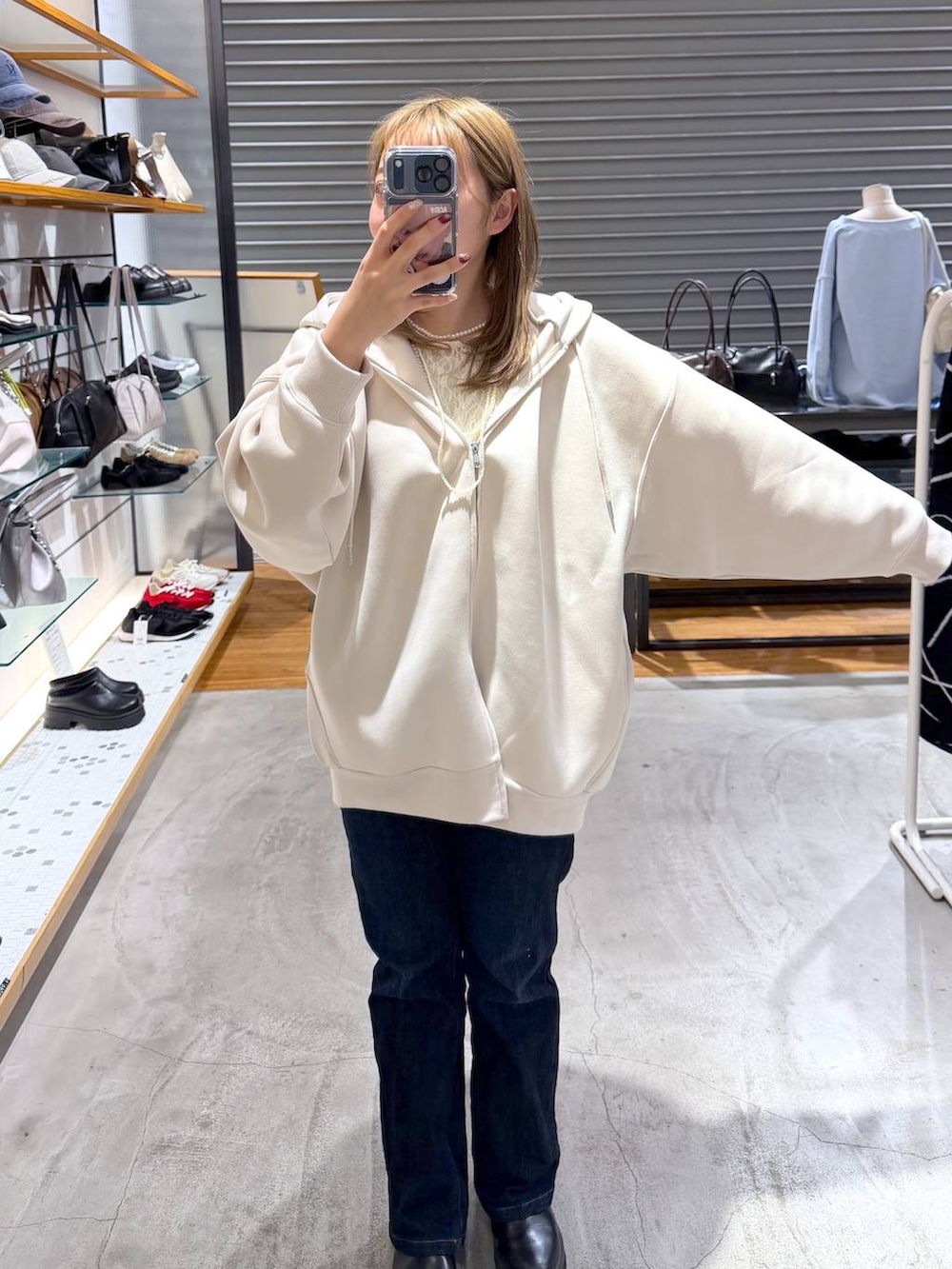 ホワイト系のパーカー、ブルー系のデニムパンツ、ホワイト系のTシャツ/カットソーを着用したレディースの春コーディネートの7枚目の写真