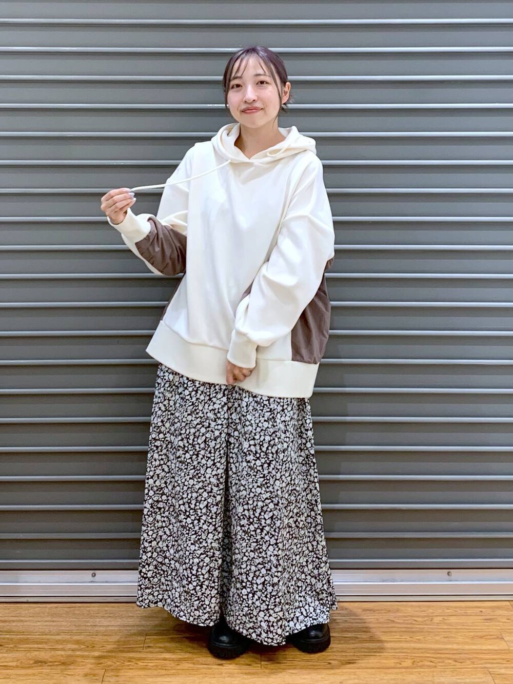 ホワイト系のショルダーバッグ、ブラック系のブーツ、ホワイト系のパーカーを着用したレディースの冬コーディネートの5枚目の写真